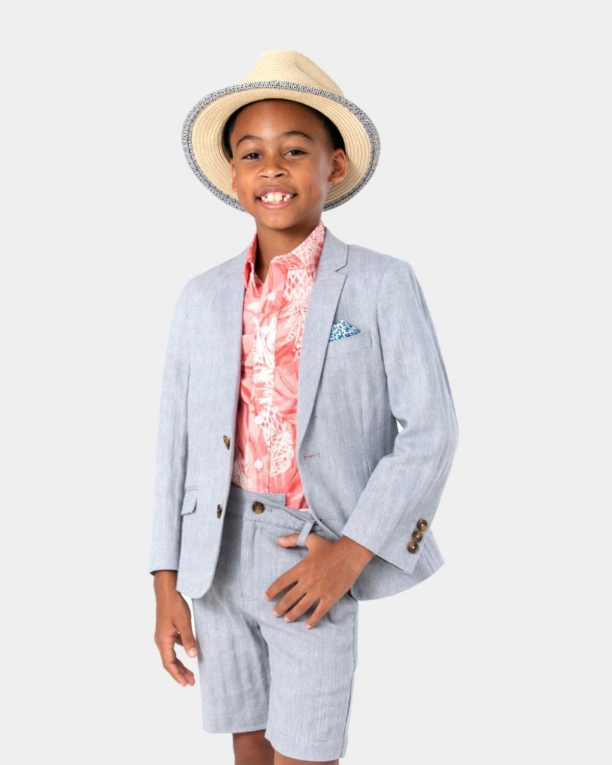 Stylish boy in a coral pineapple shirt and light suit, ready for a day of fun and festivities in high-quality kids clothes.
