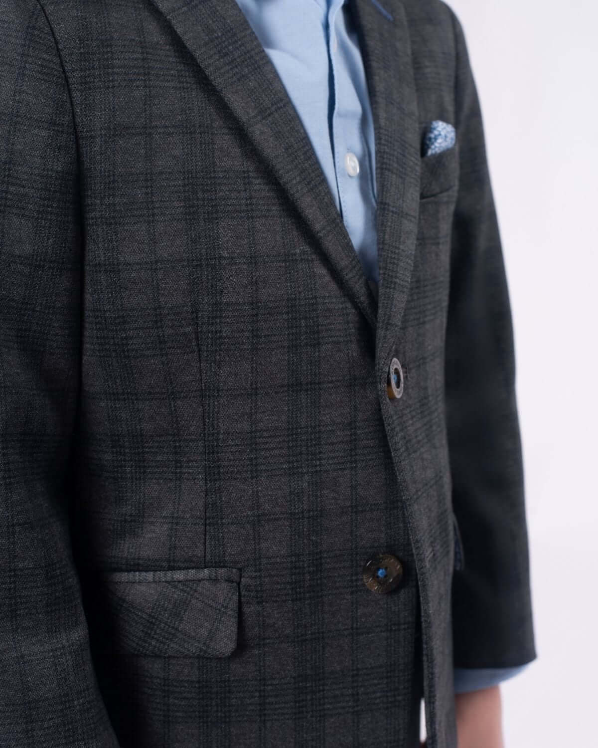 Stylish boy in grey plaid mod suit, showcasing sleek tailoring and a chic pocket square—perfect for trendy kids clothes!