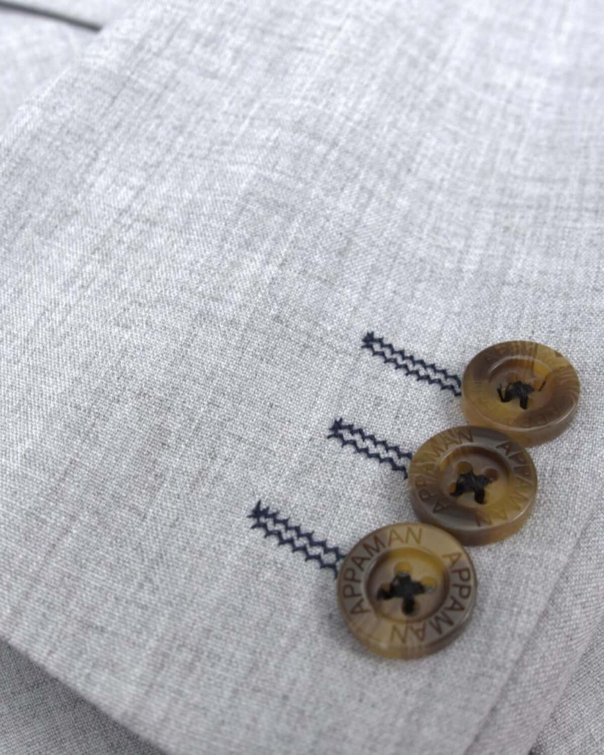 Chic close-up of grey stretchy mod suit details with stylish buttons and stitching—perfect for kids who love to stand out!