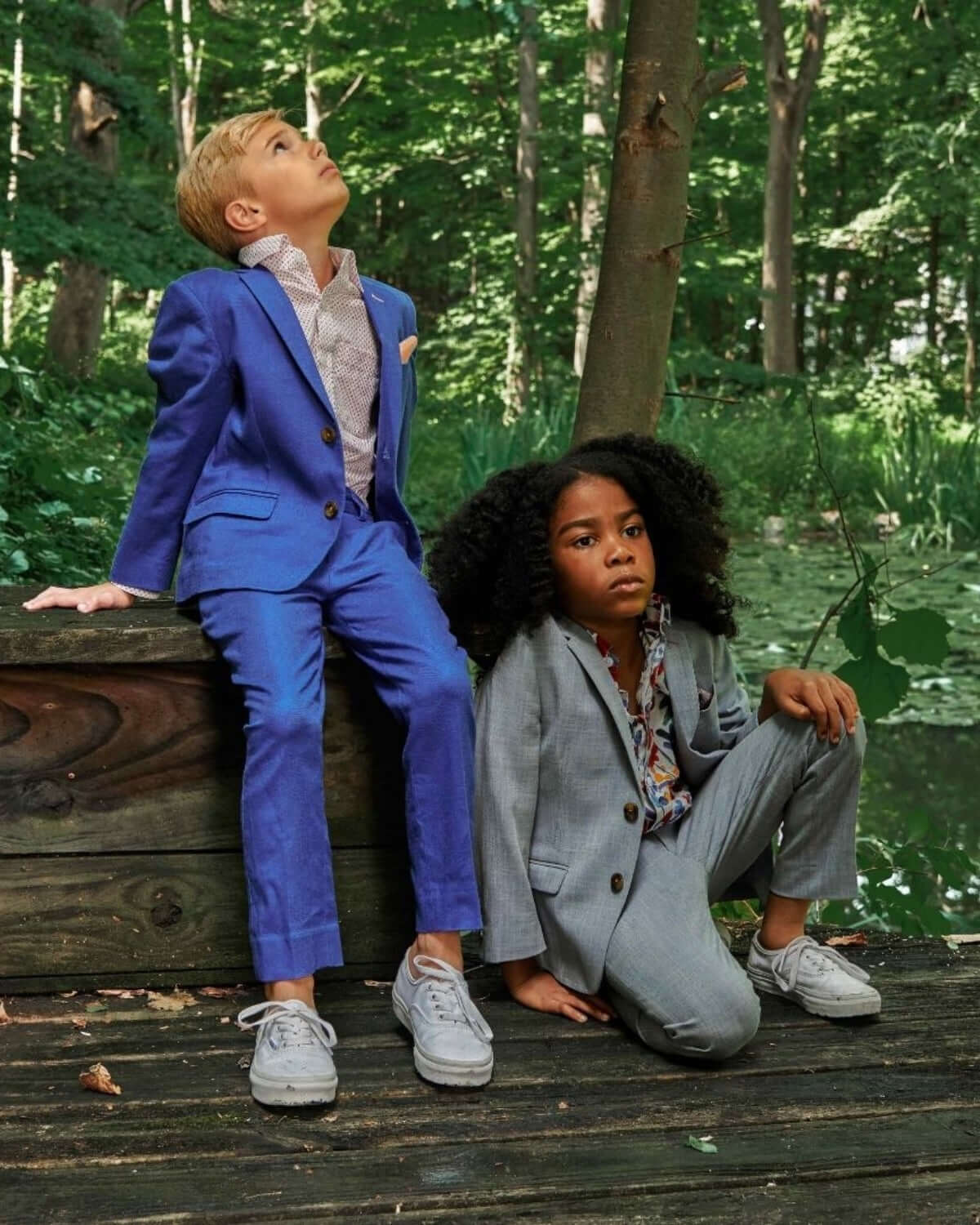 Two children in suits outdoors, showcasing the Nautical Blue Stretchy Mod Suit and stylish gray outfit.
