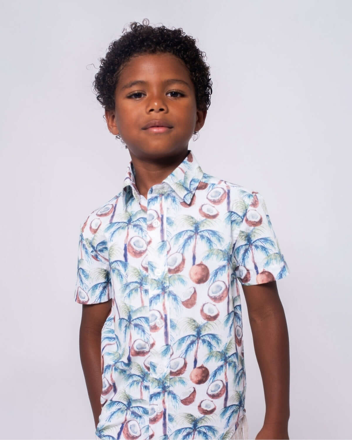 Coconut Palms Day Party Shirt worn by a boy, featuring a vibrant coconut and palm tree design.