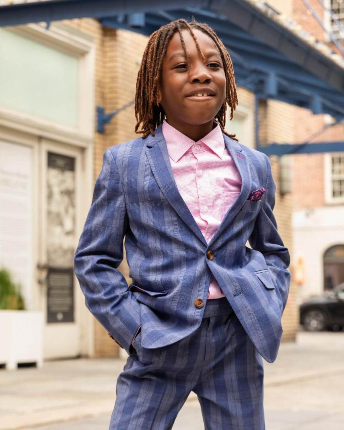 Stylish boy in a navy striped suit over a Laveno Pink shirt—great kids clothes for confident kids!