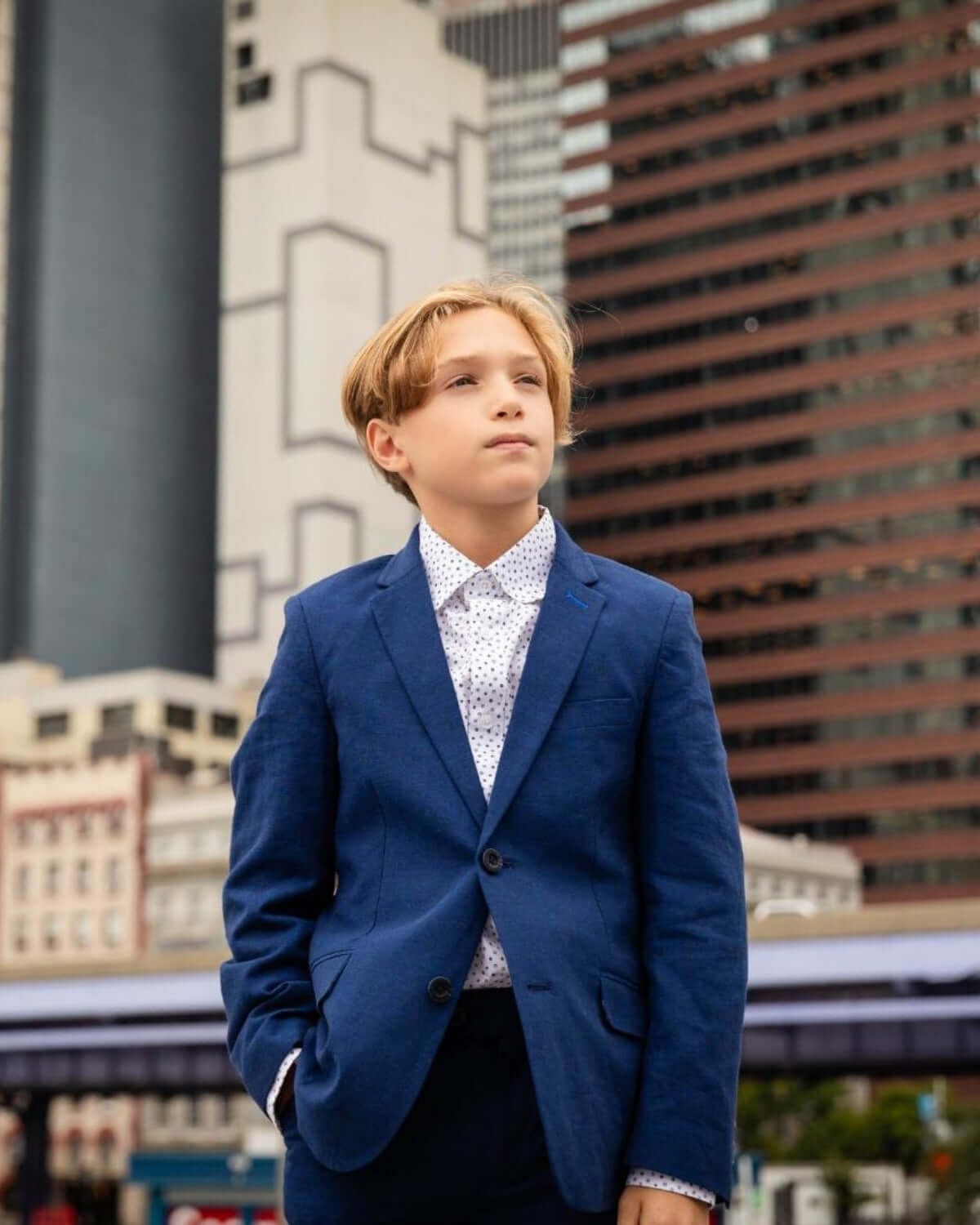 Stylish boy in a blue suit, exuding confidence in an urban backdrop—perfect for special occasions and back to school.