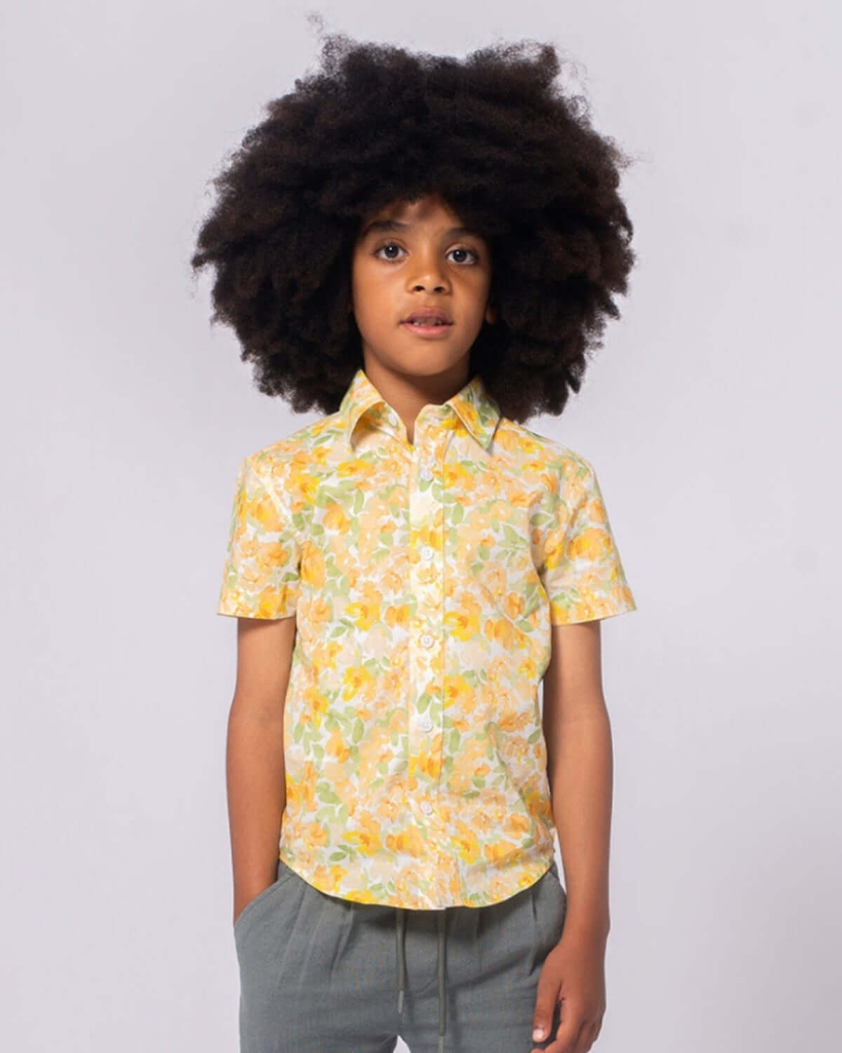 Boy wearing Spring Bouquet Day Party Shirt with vibrant floral design and short sleeves.