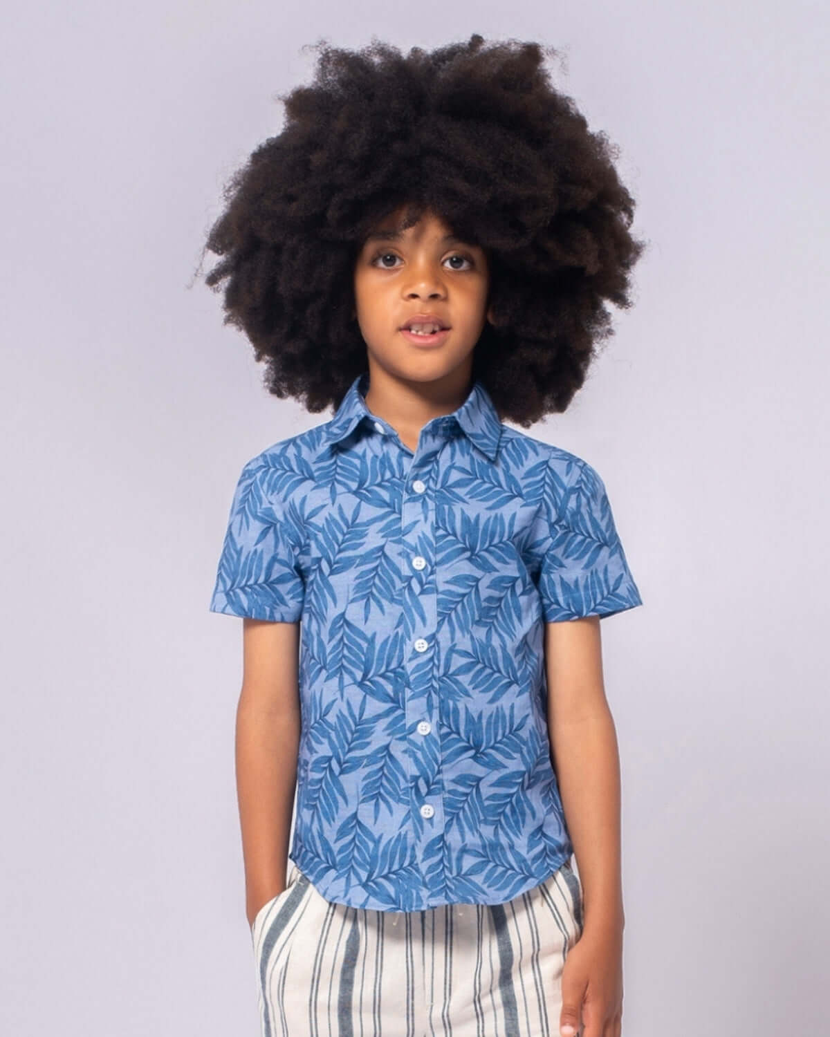 Stylish boy rocking a tropical print summer shirt, ready for fun-filled days in stylish kids clothes!