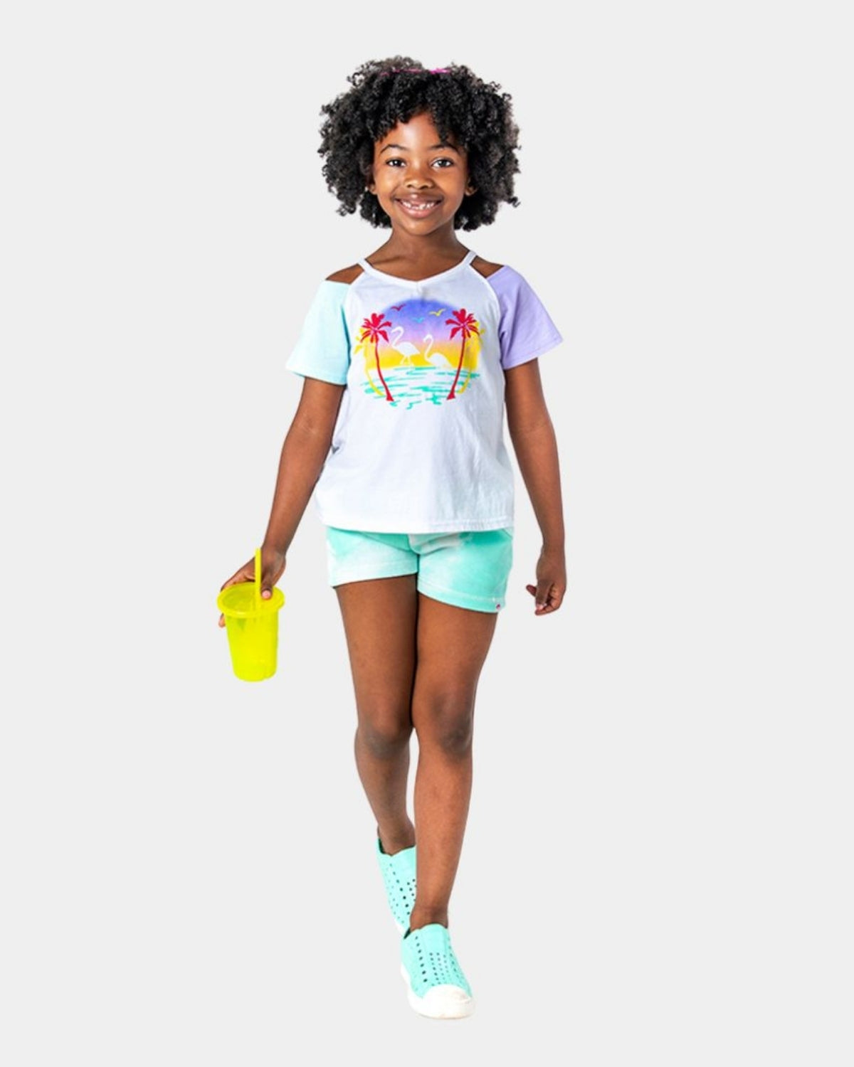 Stylish girl rocking Aqua Cloud Majorca Shorts with a colorful tee and vibrant drink, ready for summer fun!