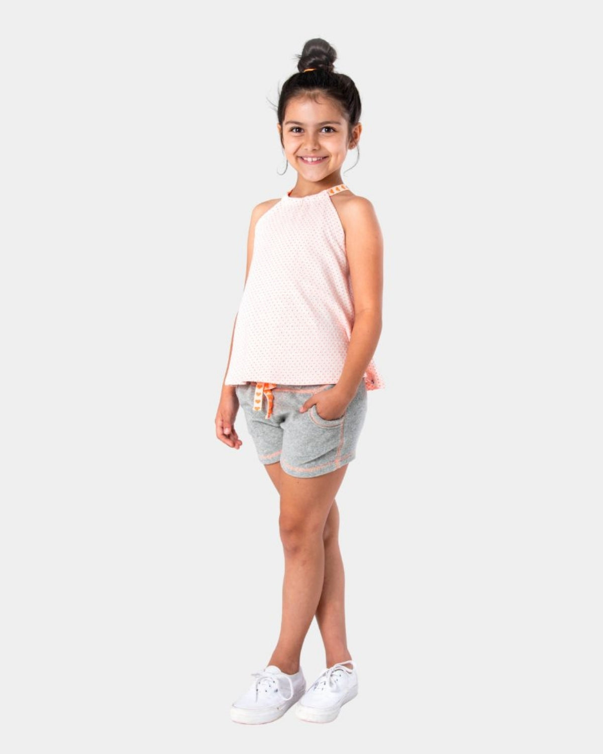 Cheerful kid in grey Majorca shorts and pink tank, ready for summer fun in stylish kids clothes!