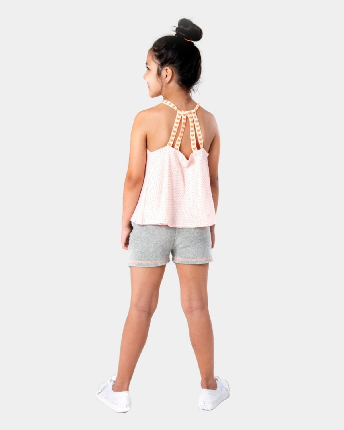 Stylish girl in grey Majorca shorts and pink novelty dots tank, ready for summer fun with playful orange heart straps!