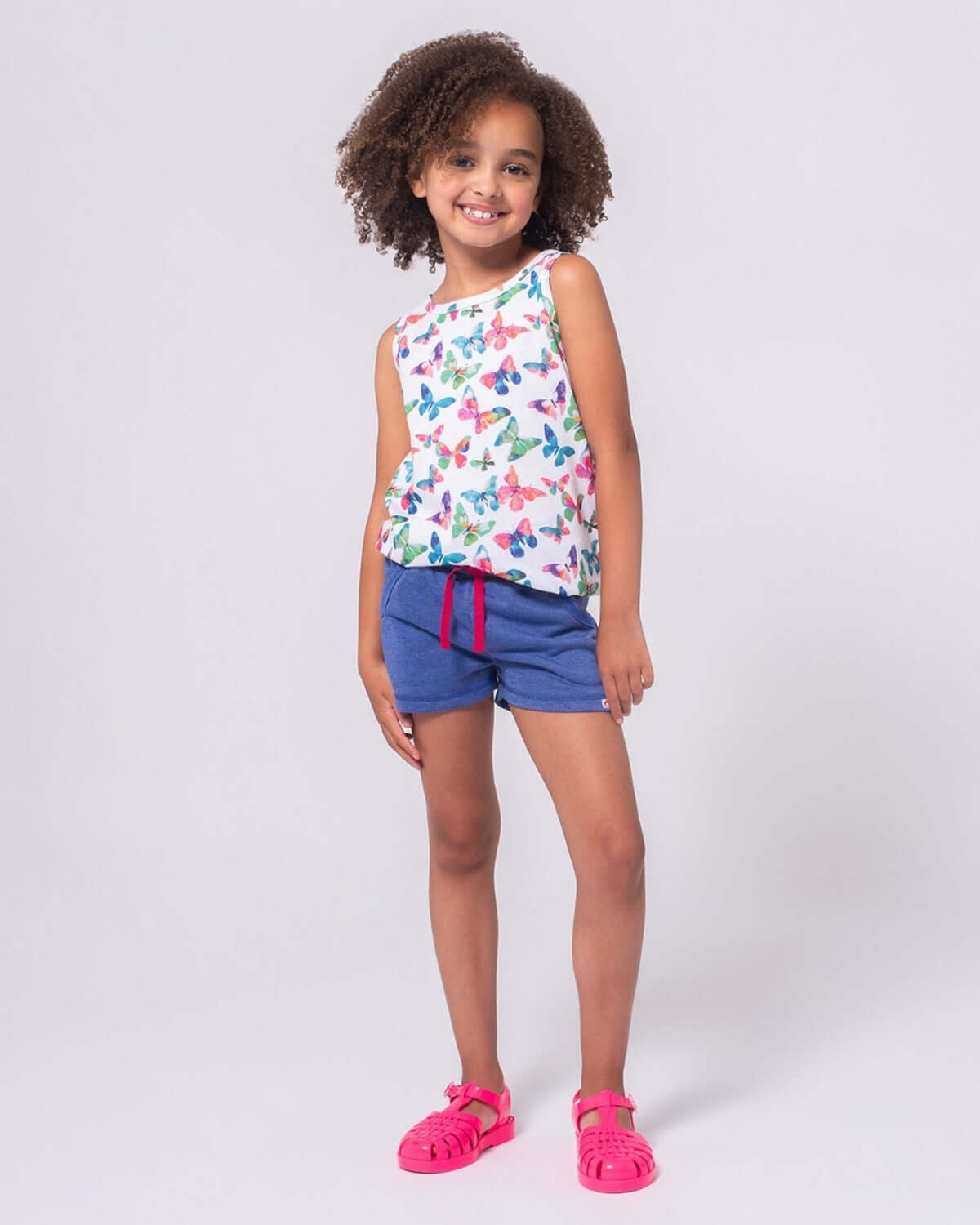 Stylish girl in Navy Sparkle Majorca Shorts, ready for summer fun in playful, durable kids clothes!