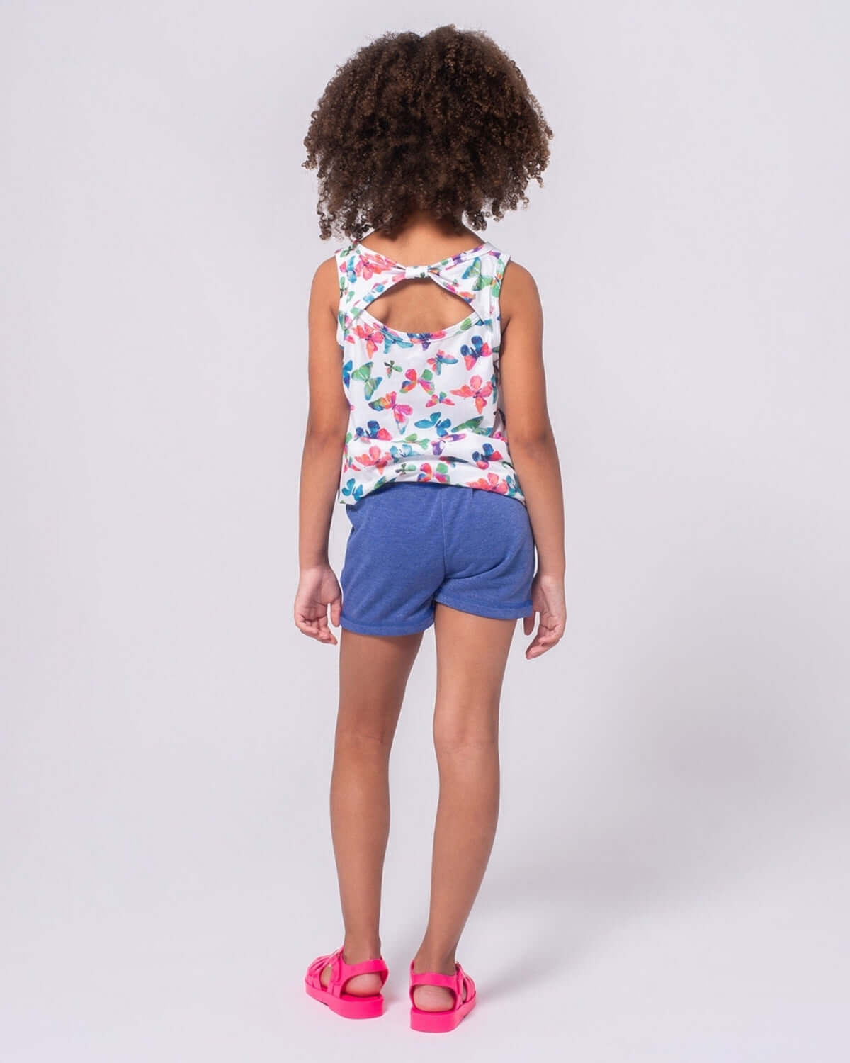 Stylish girl in floral tank and navy sparkle shorts, ready for summer fun in high-quality kids clothes!
