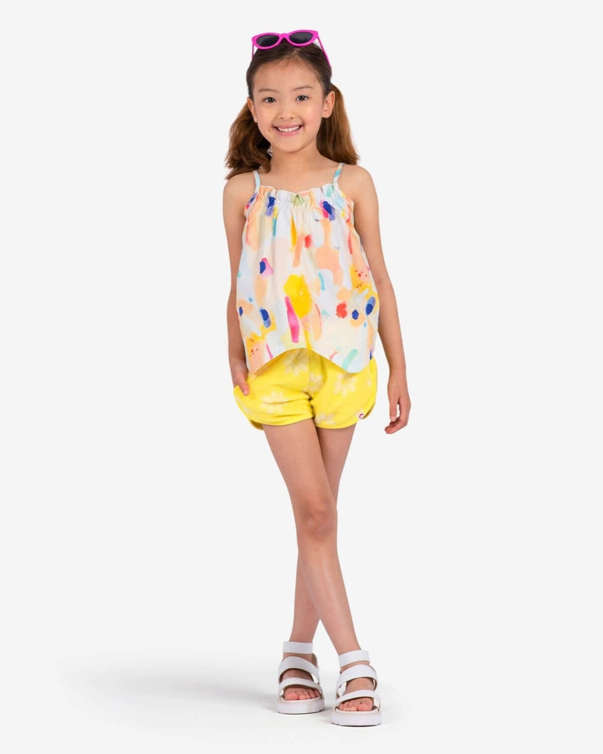 Bright and playful girl in colorful top and sunny shorts, ready for summer fun in stylish kids clothes.