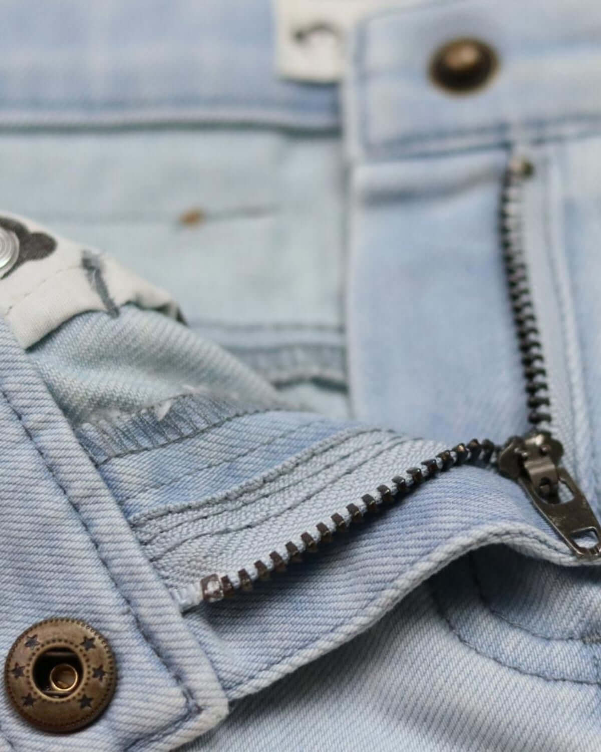 Close-up of zippered waistband on Sun Wash Rhodes Shorts, showcasing high-quality denim for kids' stylish summer adventures.