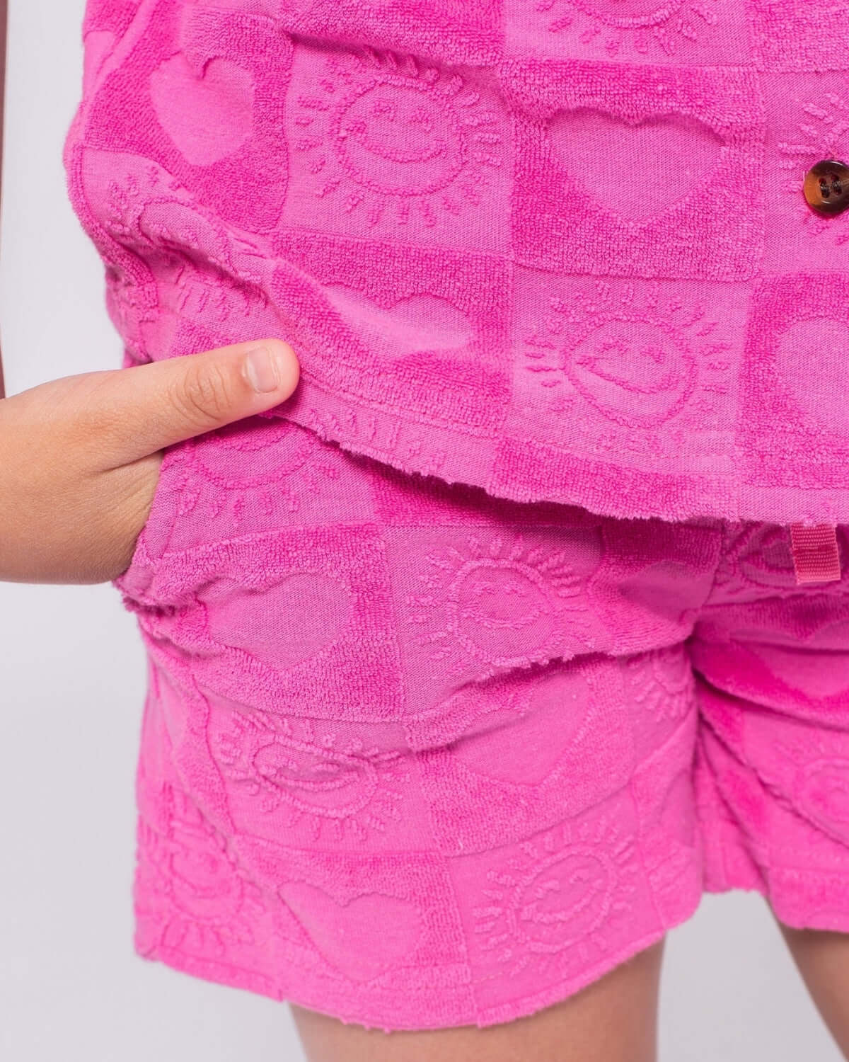 Stylish pink resort shorts with heart patterns for kids, perfect for sunny days and beach adventures!