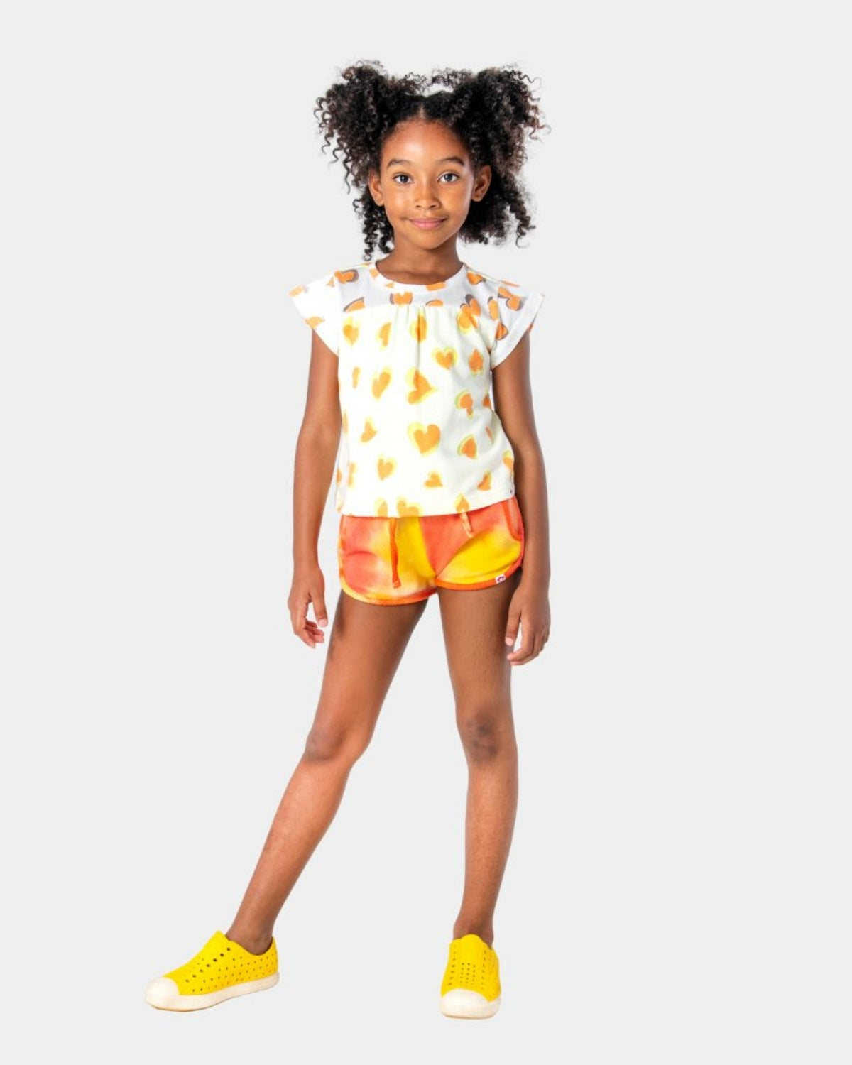 Trendy girl rocking sunny Sunray Sierra Shorts with a playful heart top—perfect for stylish summer adventures!