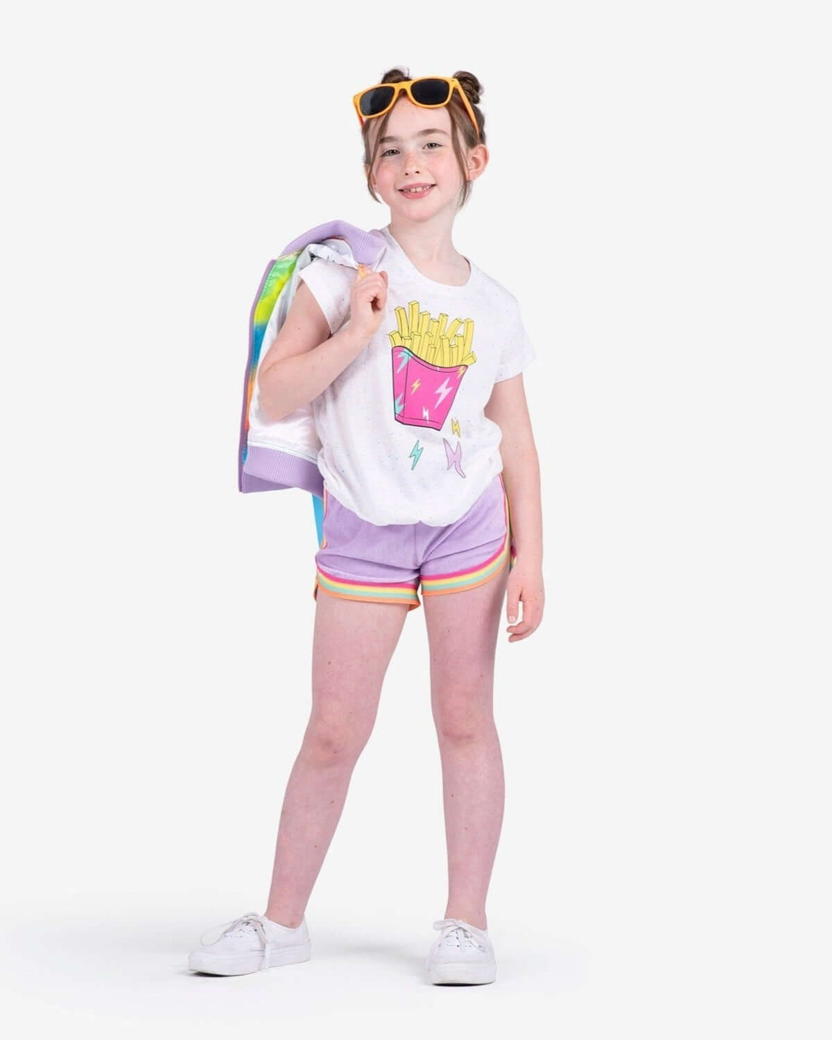 Trendy girl rocking sweet lavender shorts with rainbow trim and fun graphic tee, perfect for stylish spring adventures!
