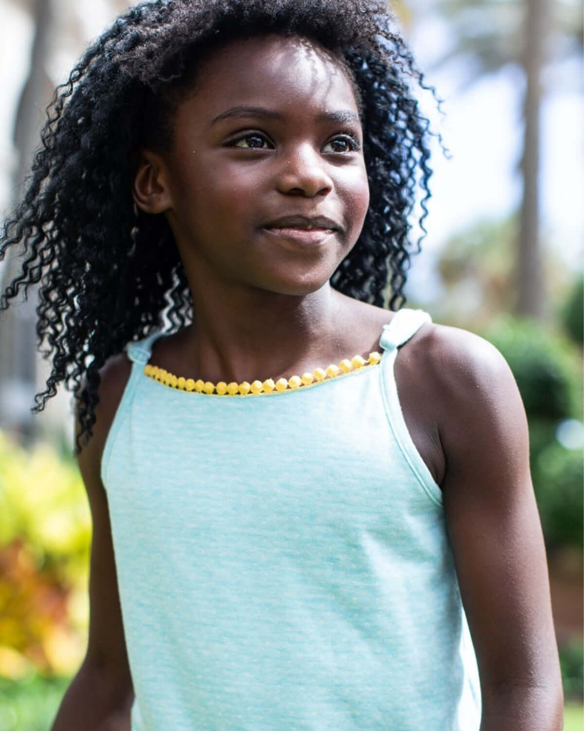 Aqua Novia Romper on a girl with a playful yellow outline, perfect for adventures and playdates.