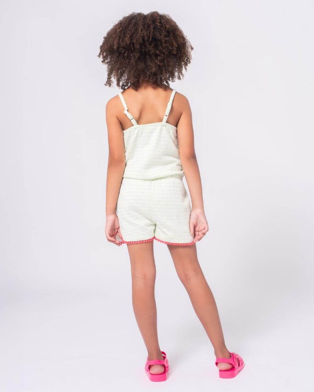 Light Green Stripe Novia Romper back view on a girl with curly hair, showcasing its stylish design.