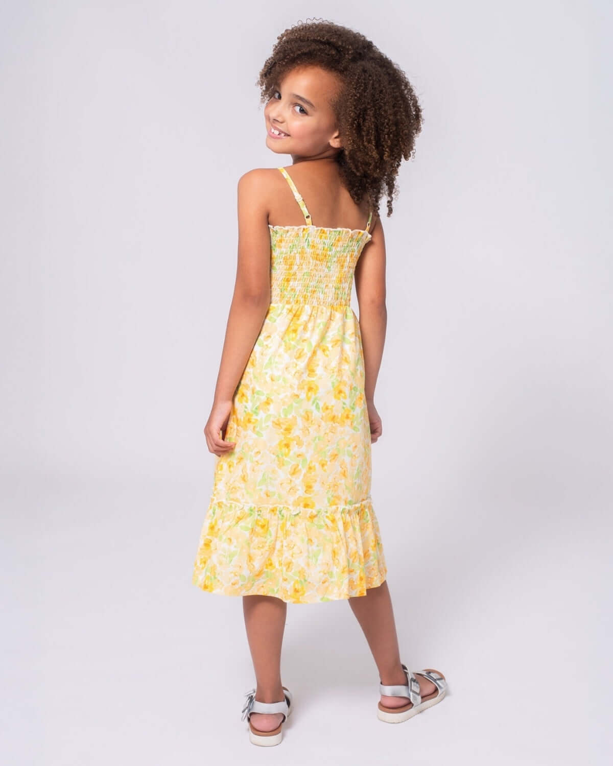 Spring Bouquet Madison Dress featuring a girl in a bright yellow floral dress with a playful design.