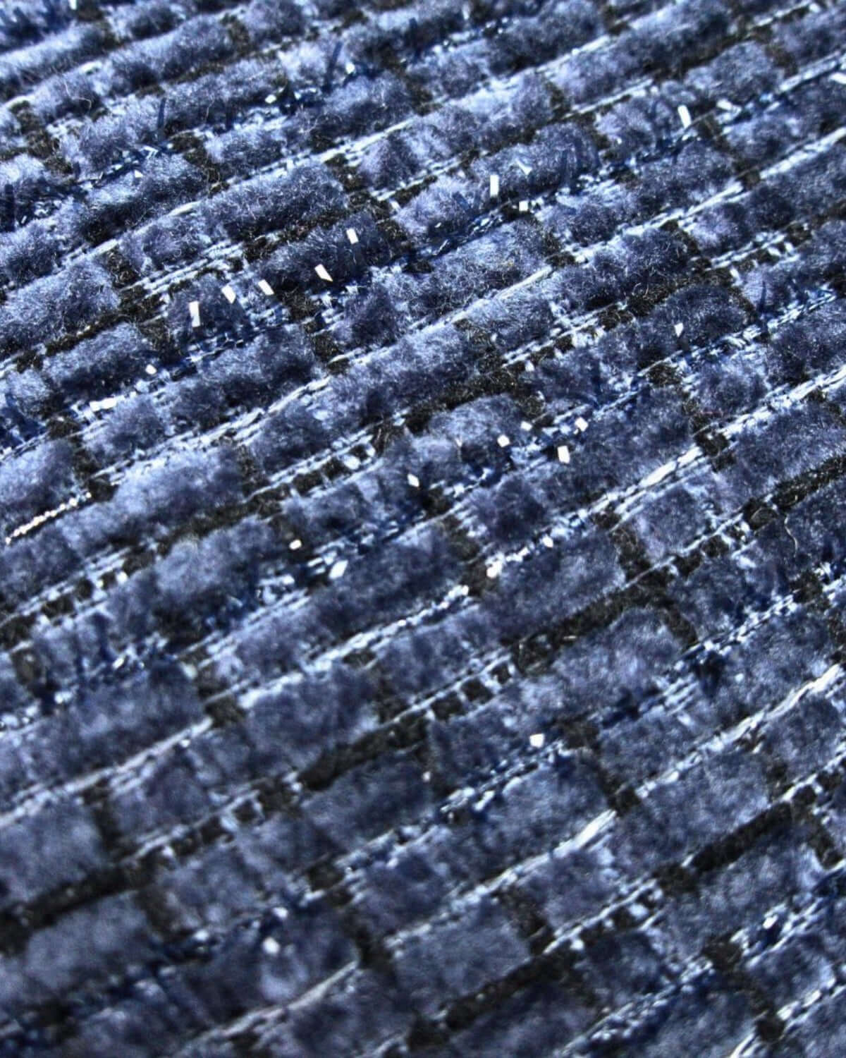 Close-up of plush navy velvet fabric showcasing stylish raised stripes—perfect for cozy winter vibes in kids clothes.