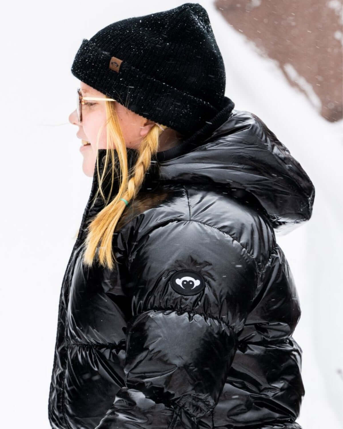 Stylish girl in a black glitter puffy coat and cozy beanie, ready for winter adventures!