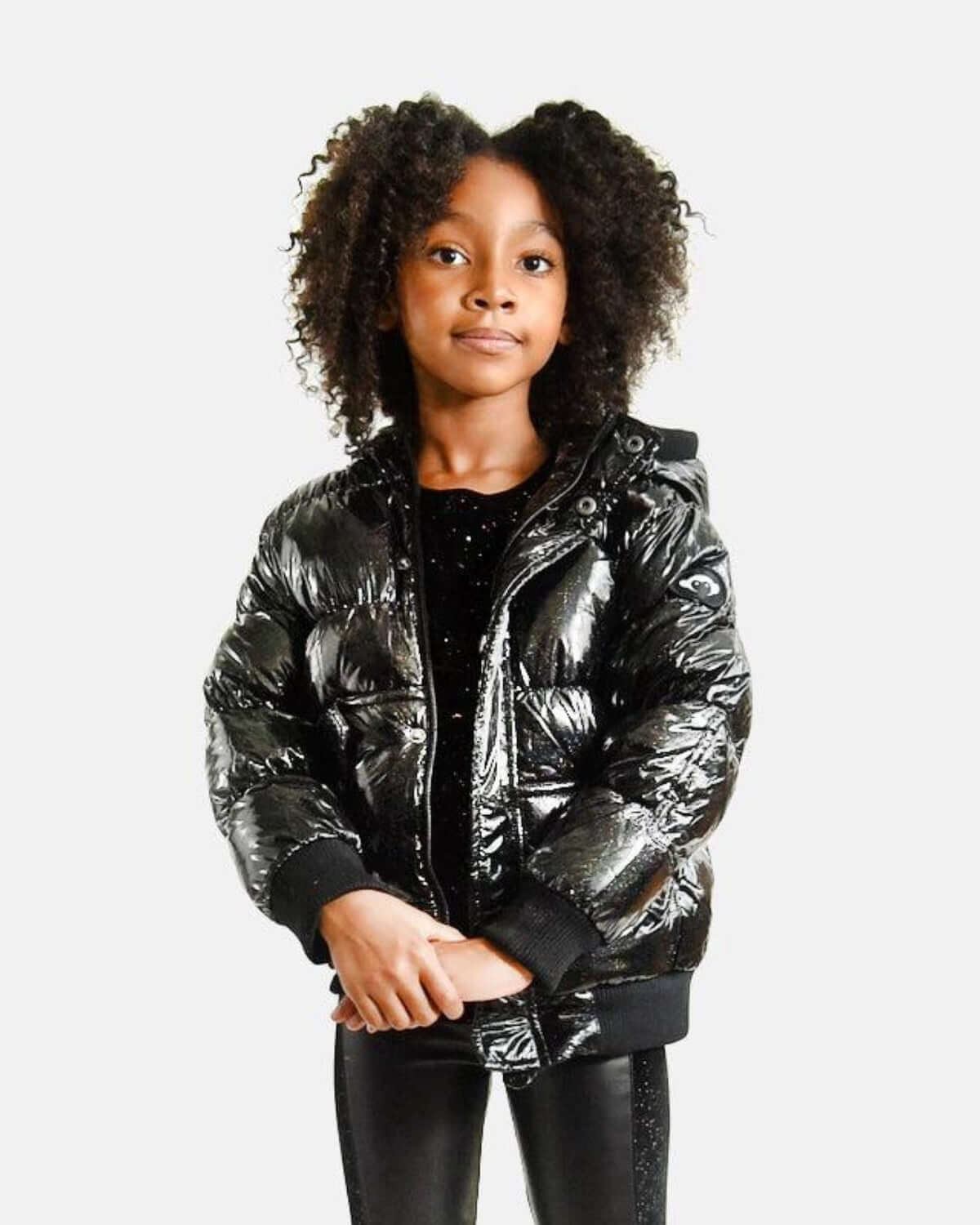 Stylish girl in a shiny black puffy coat, perfect for cozy days and sparkling moments in kids' fashion.