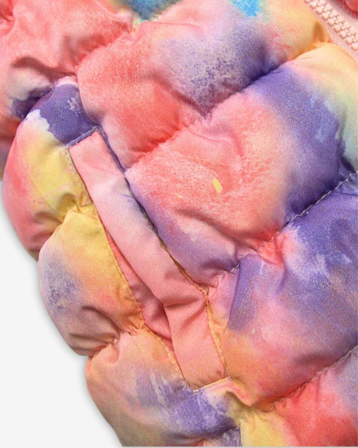 Close-up of the colorful candy cloud pattern on Appaman's reversible vest, showcasing its vibrant quilted texture.