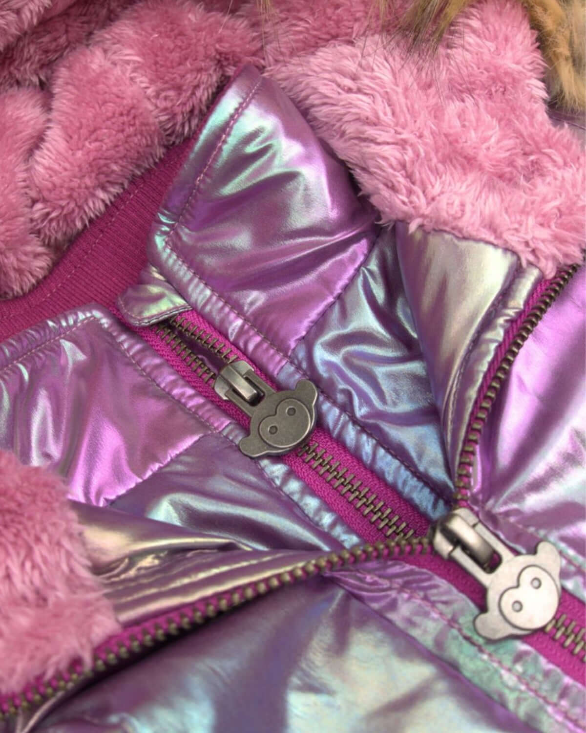 Close-up of shiny pink puffer coat with soft sherpa lining—stylish warmth for your little fashionista.