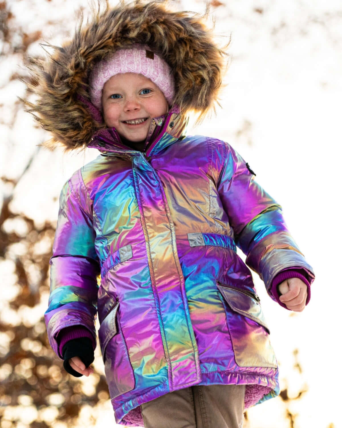 Joyful kid in a shimmering coat with a furry hood, ready to shine in winter adventures! Stylish and cozy for cold days.
