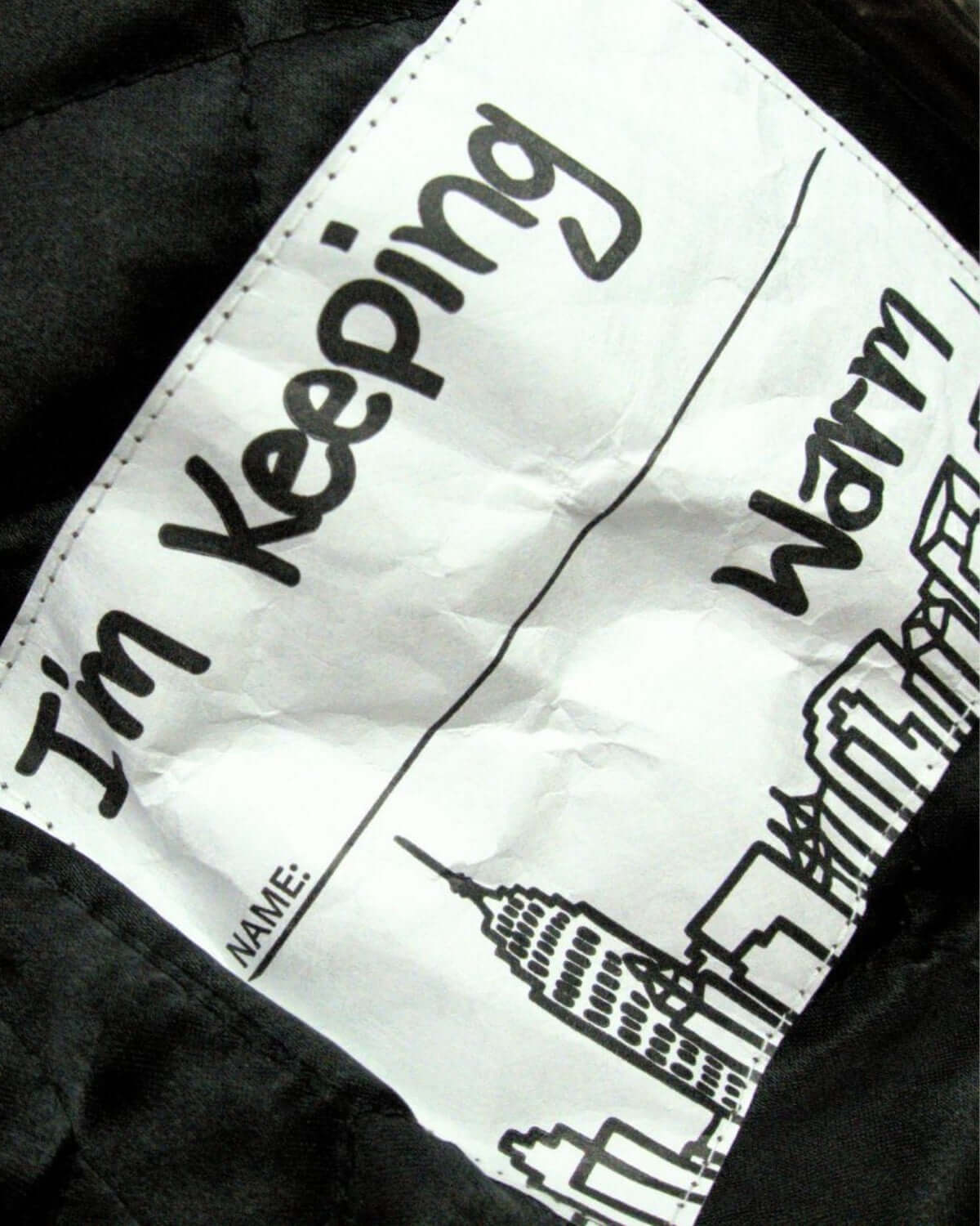 Inside label saying 'I'm Keeping Warm' in a stylish winter coat, perfect for cozy adventures this season.