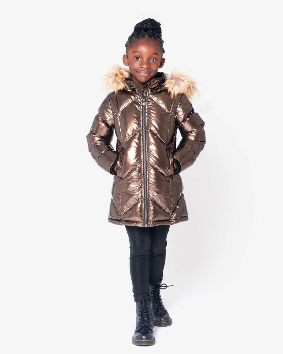 Stylish girl in copper Nova Long Coat with faux fur hood, perfect for warm winter adventures in trendy kids clothes.
