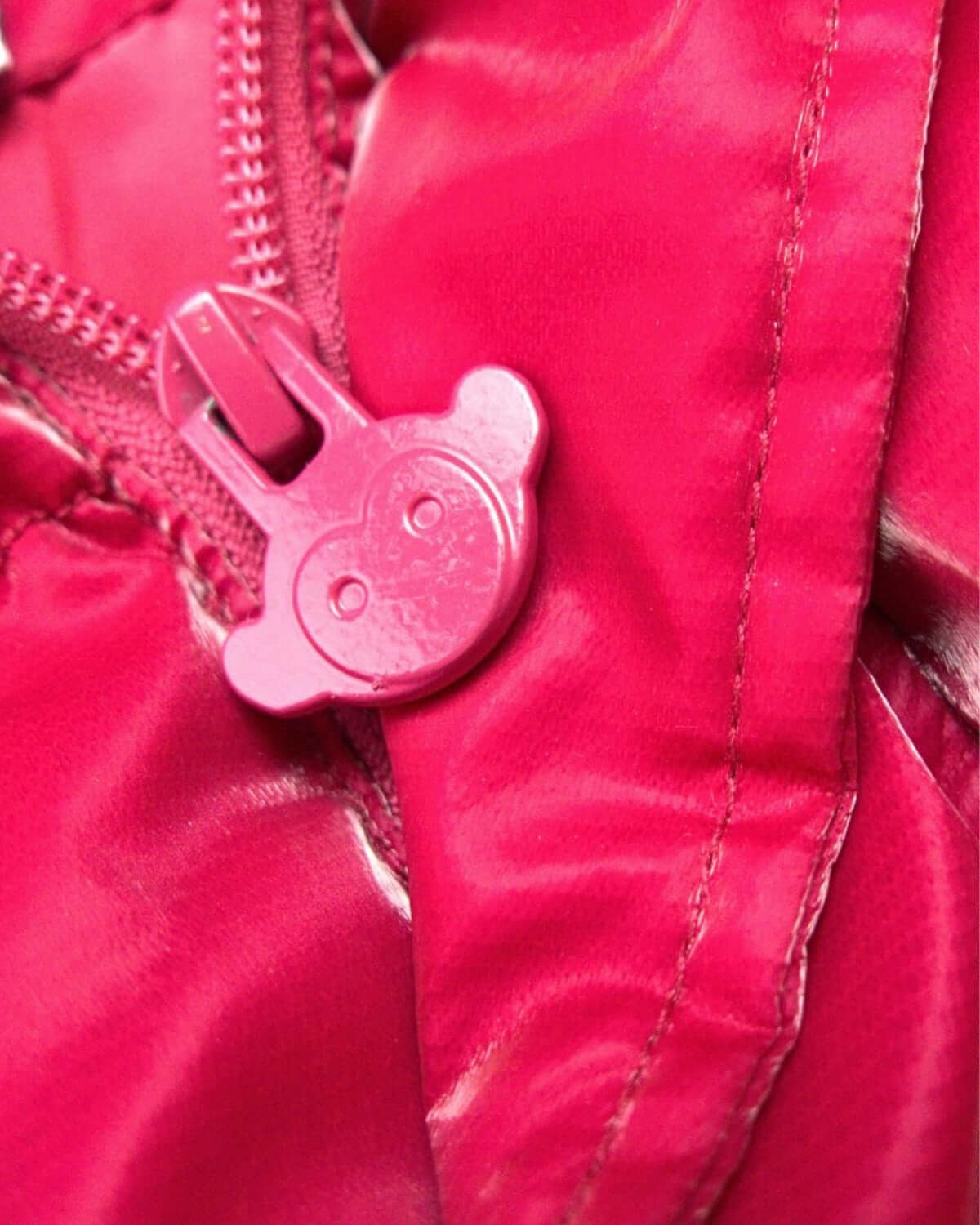 Close-up of the playful pink zipper tag on the Deep Pink Puffy Coat, designed for cool kid style and comfort.