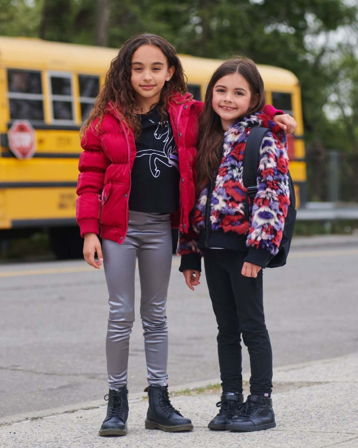 Two stylish girls in puffy coats, showcasing playful kids clothes for chic winter adventures and back to school fun.