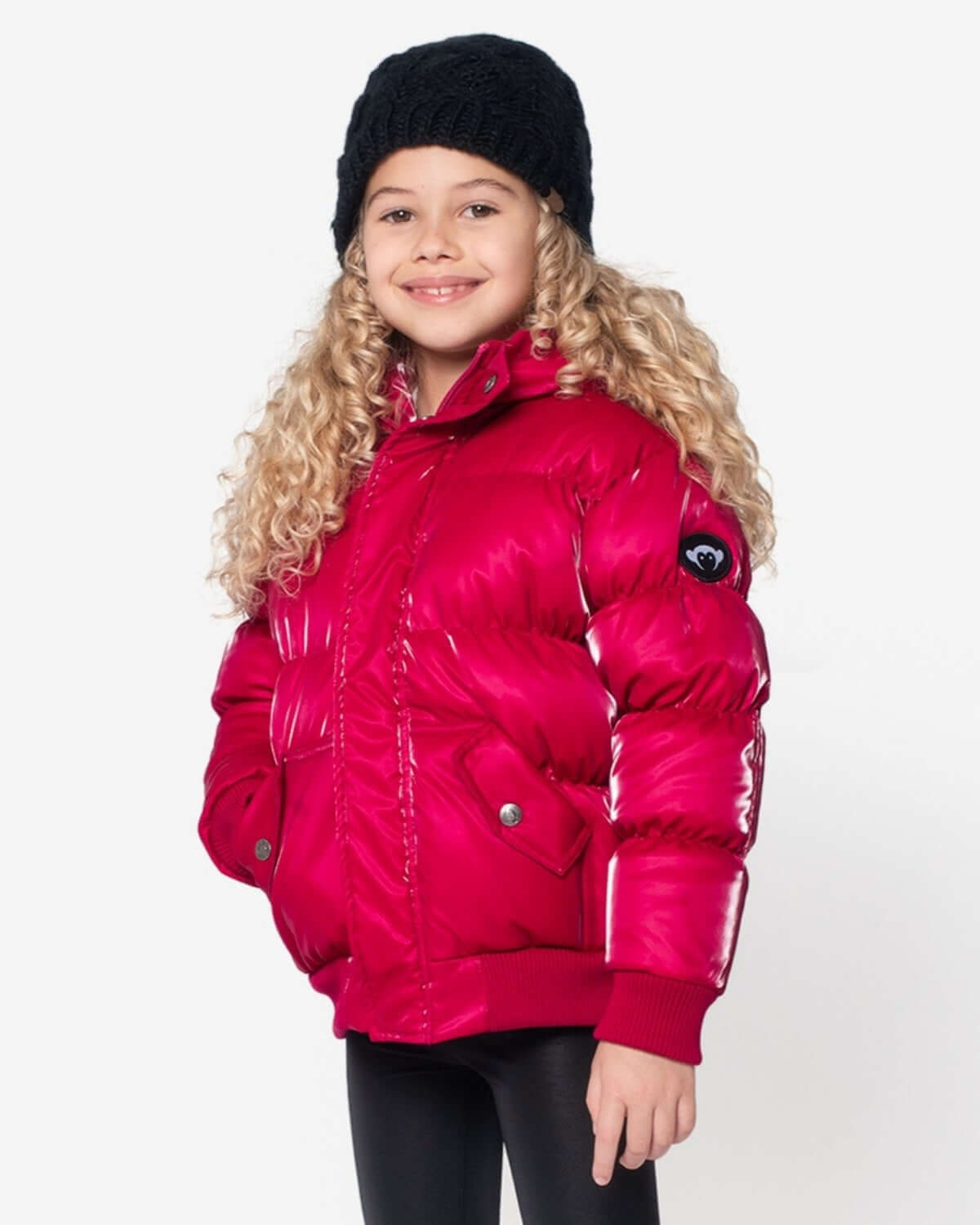 Stylish girl rocking a deep pink puffy coat and cozy black beanie, ready for winter adventures! High-quality kids clothes.