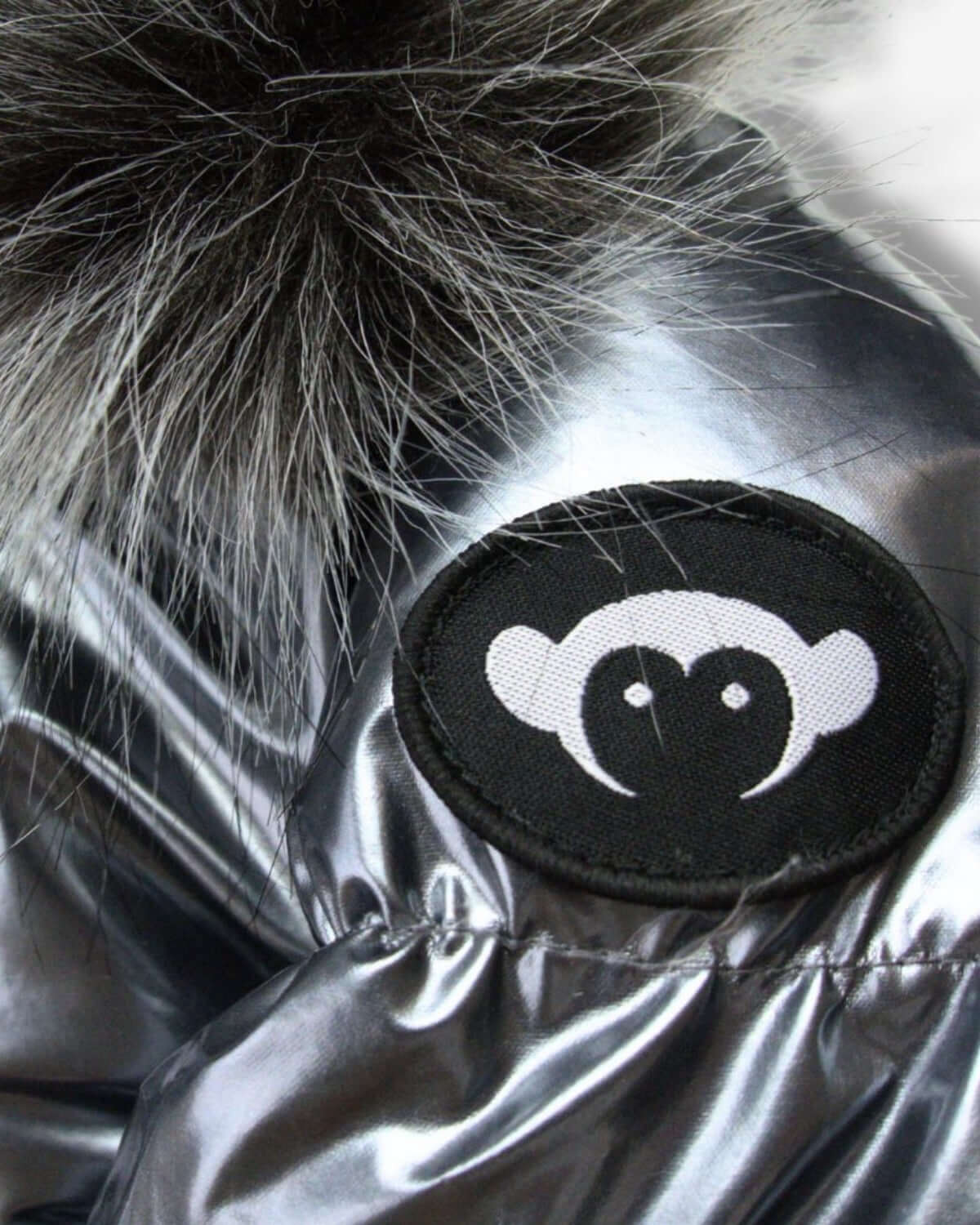 Close-up of the Gunmetal Kyla Puffer Coat's stylish patch and cozy faux fur trim—perfect for chic winter fun!