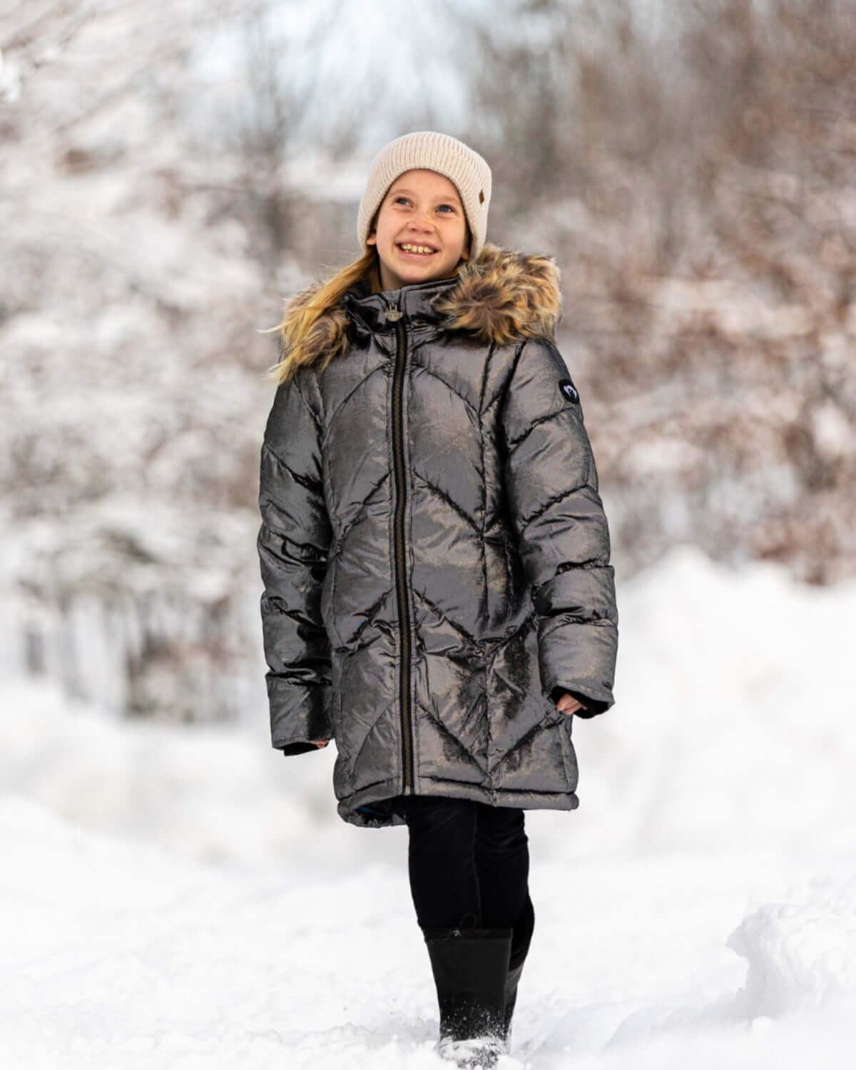 Stylish girl in Moon Stone Nova Long Coat, ready for winter fun with faux fur hood and cozy warmth.