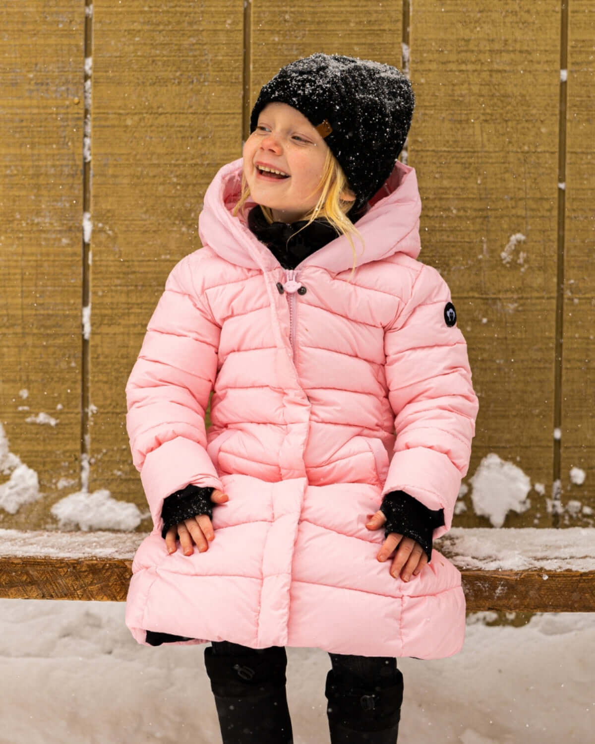 Adorable kid in a pink Lovi Long Puffer, embracing winter fun with style and warmth, perfect kids clothes for back to school!