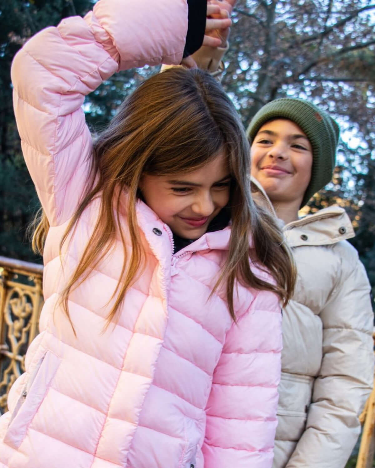 Stylish kids share fun in their cozy Lovi Long Puffer coats, ready for back-to-school adventures in high-quality warmth!
