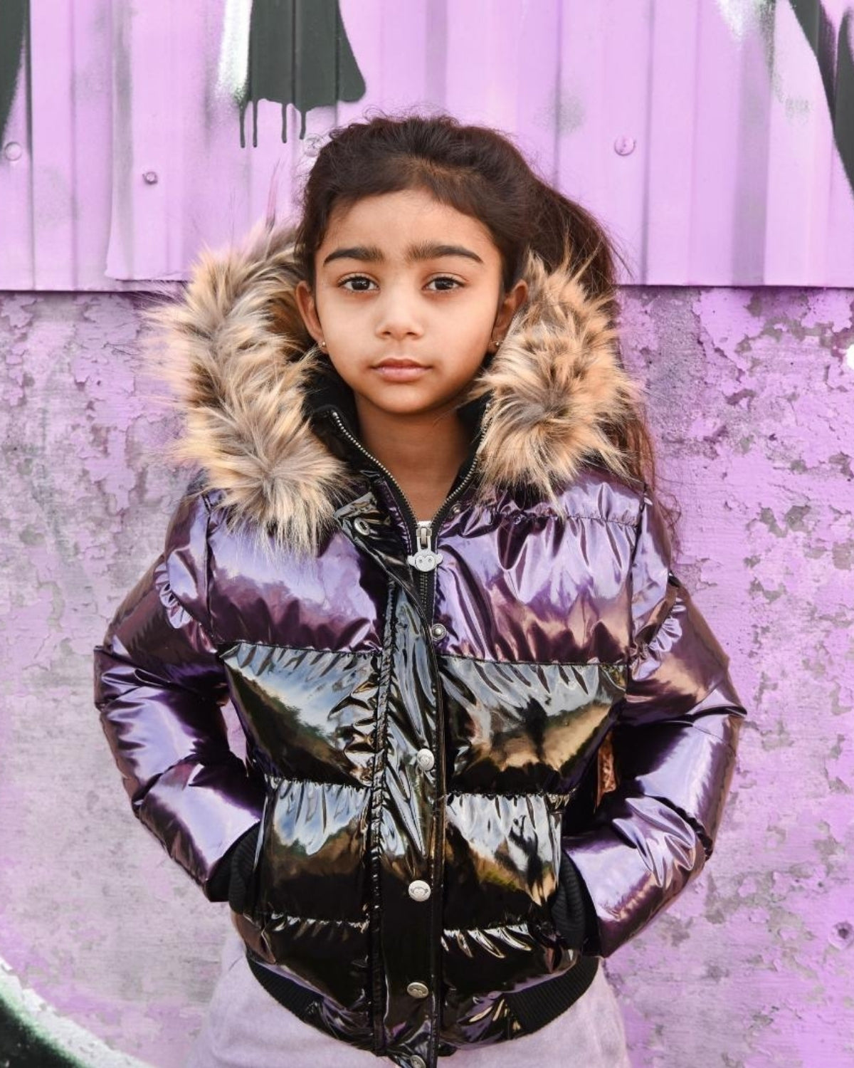 Stylish girl wearing a plum and black Kyla Puffer Coat with faux fur hood, perfect for chilly days and back to school adventures.