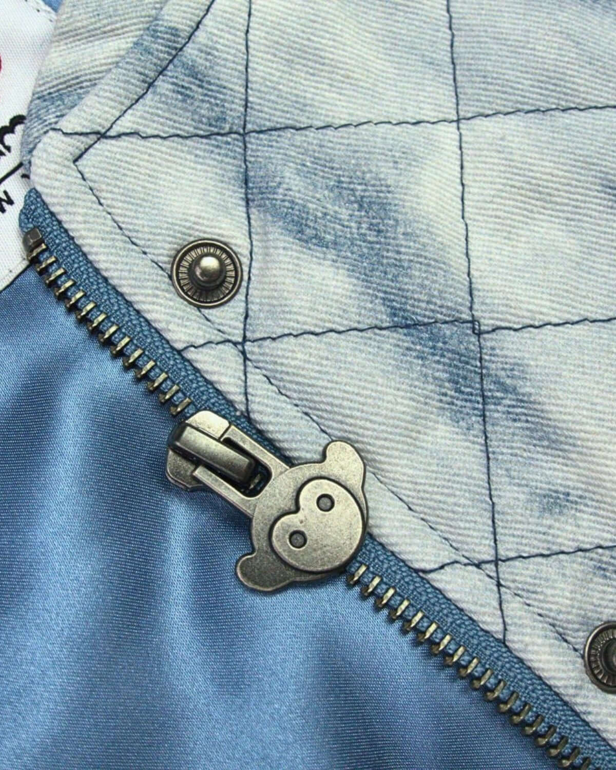 Close-up of Appaman's Hazel Jean Jacket showcasing light-washed denim, quilted texture, and playful zipper detail.