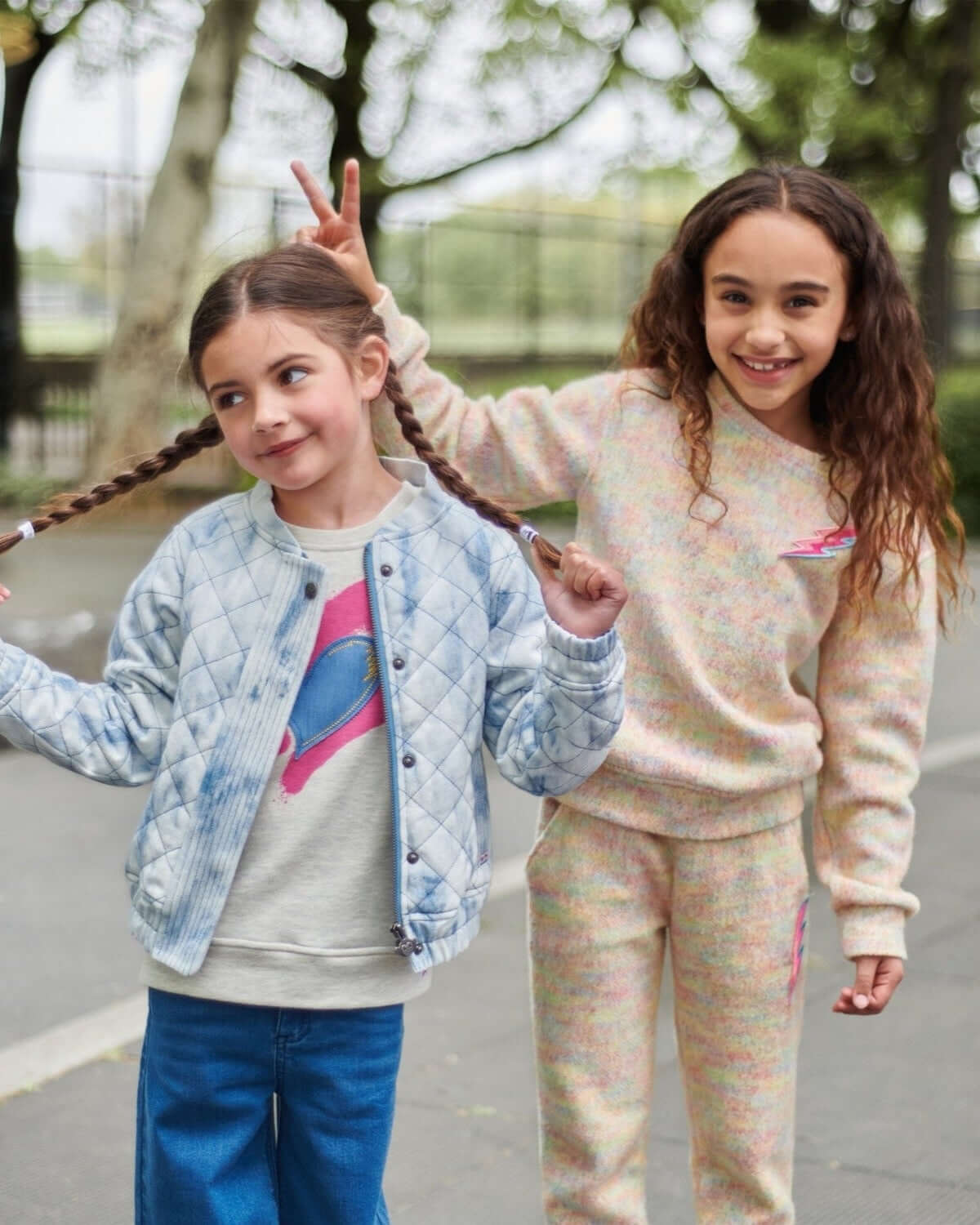 Two stylish kids enjoying the outdoors in Appaman's washed denim jacket and playful pastel loungewear.