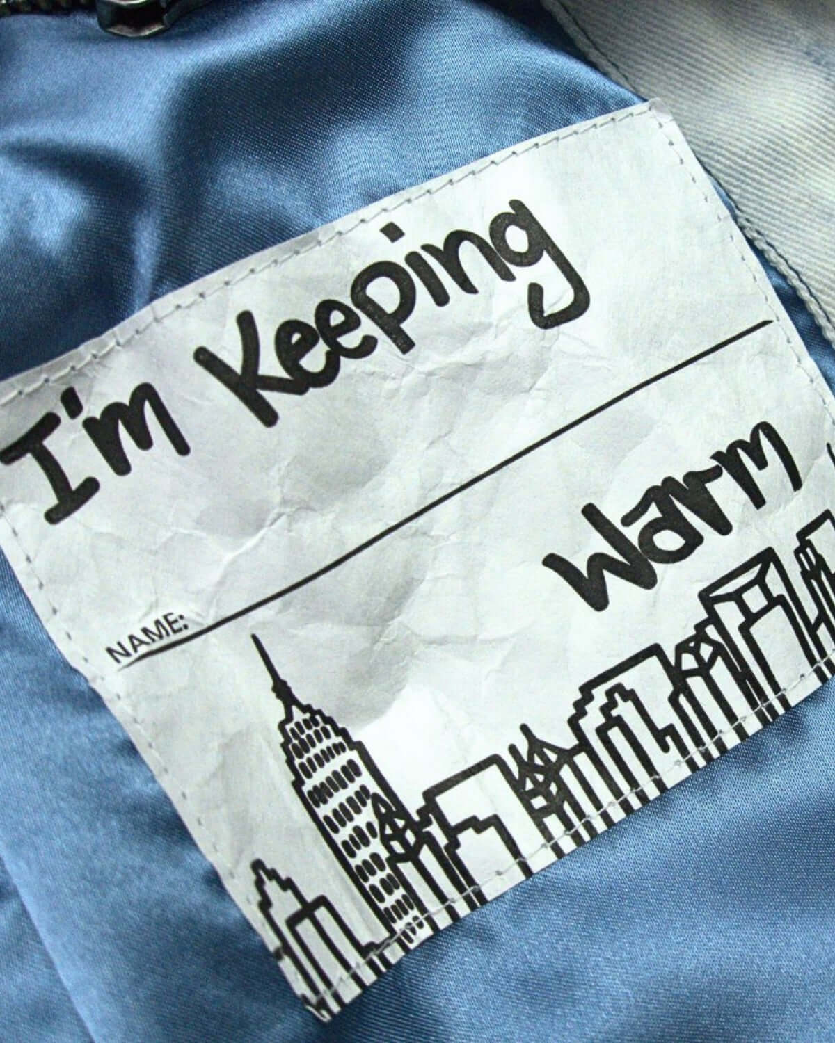 Tag inside a jacket saying "I'm Keeping Warm" with a fun city skyline—perfect for stylish, cozy kids' adventures!