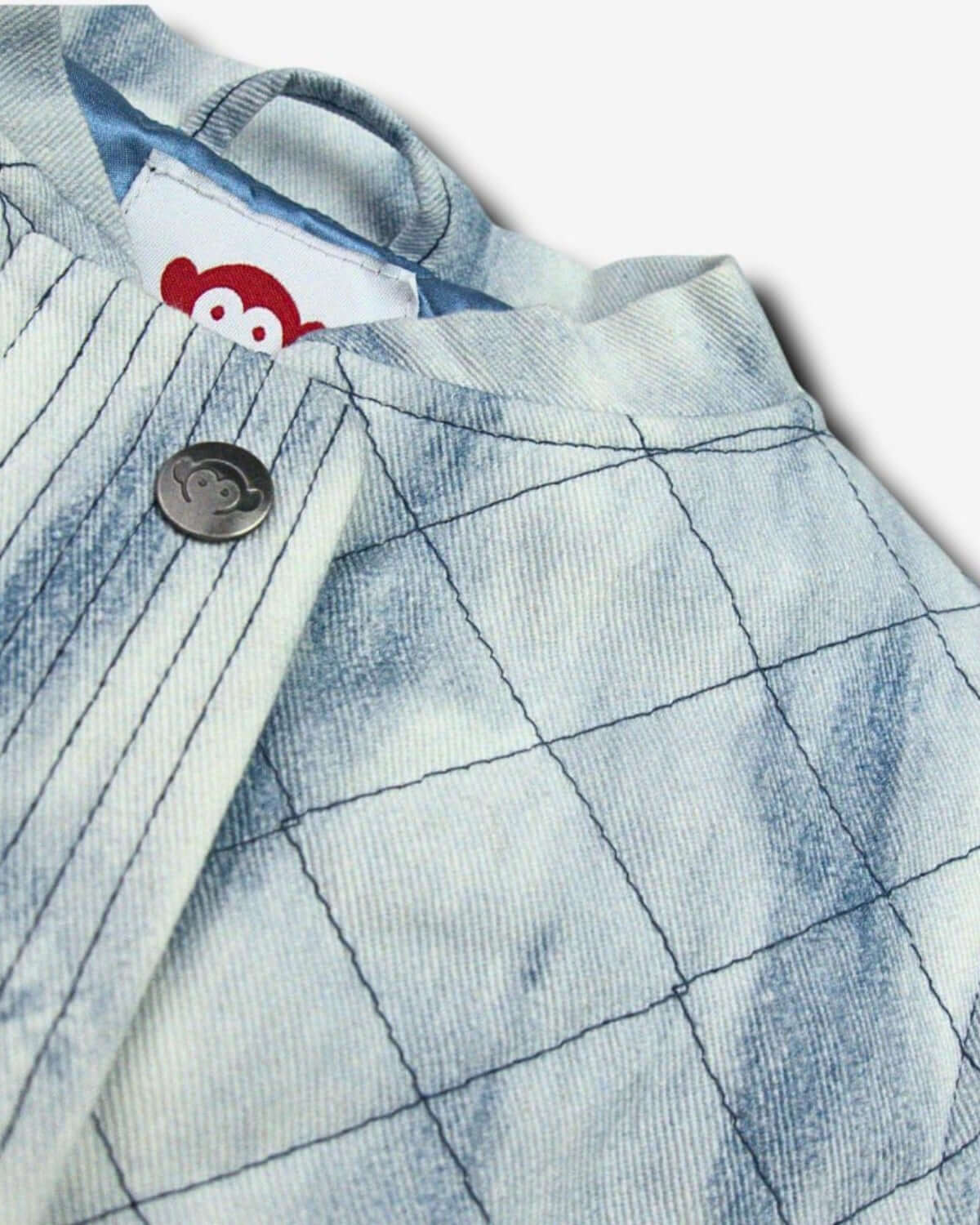 Close-up of Appaman's Washed Denim Hazel Jean Jacket, featuring playful diamond quilt pattern and easy snap button.