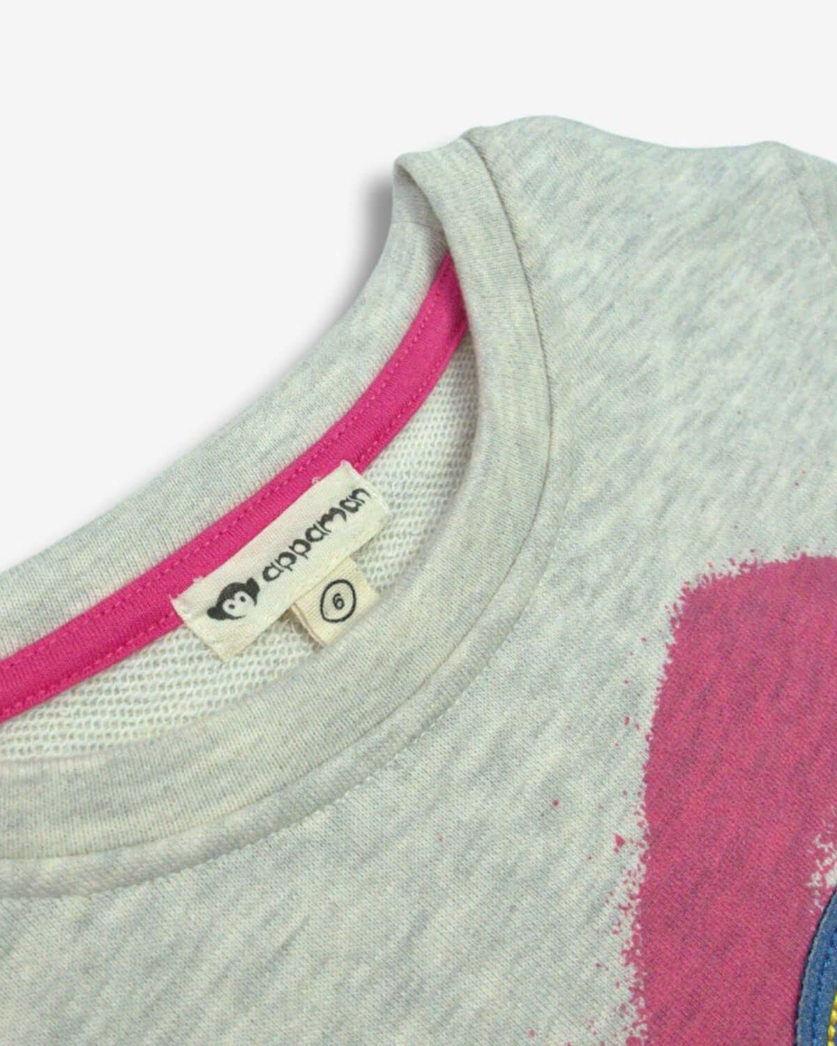 Close-up of a stylish gray Apaman sweatshirt with a bright pink collar, showcasing its playful embroidered design for kids.