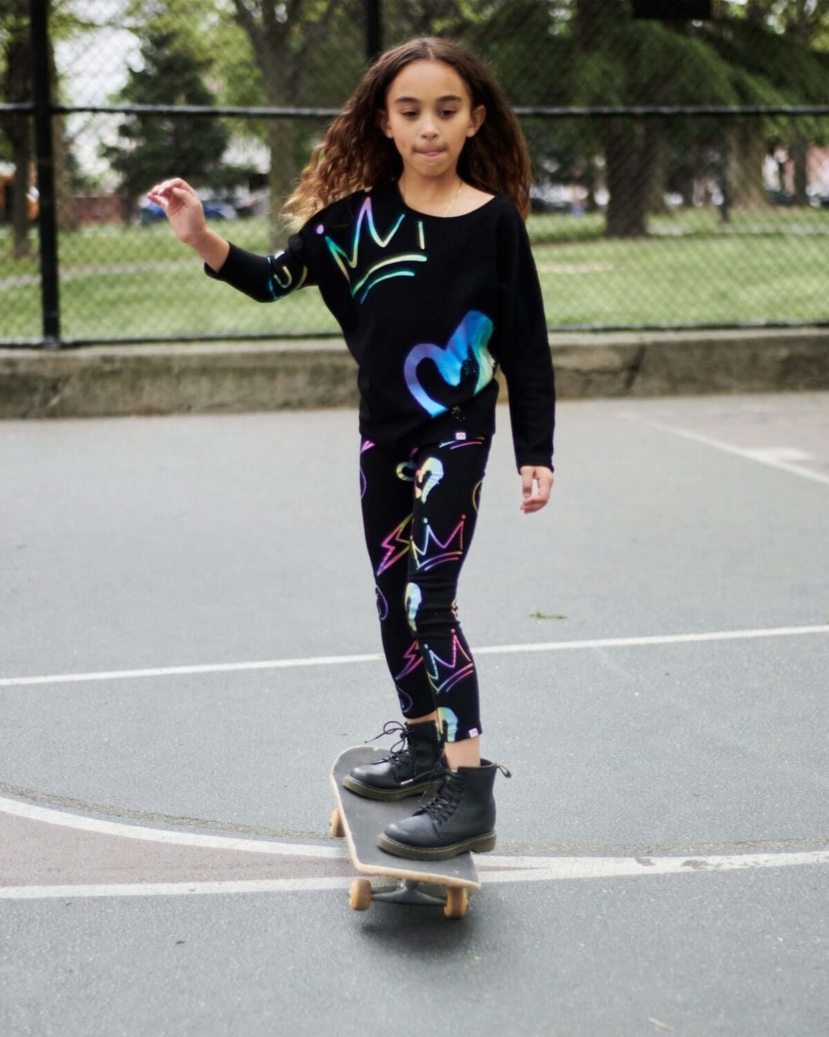 Stylish kiddo rocking a Graffiti Slouchy Sweatshirt and leggings on a skateboard—perfect for back to school fun!