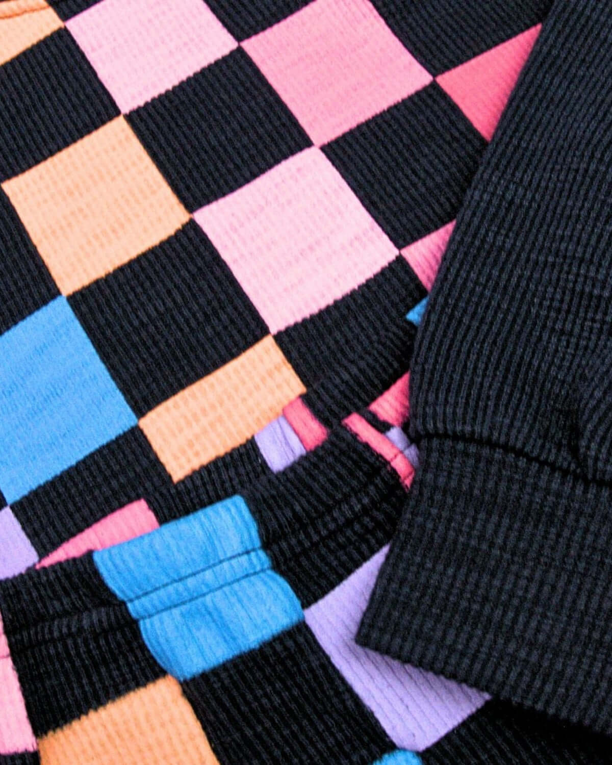 A fun close-up of the navy checkerboard Ruby Sweatshirt, showcasing vibrant colors and cozy textures for stylish kids' wear.