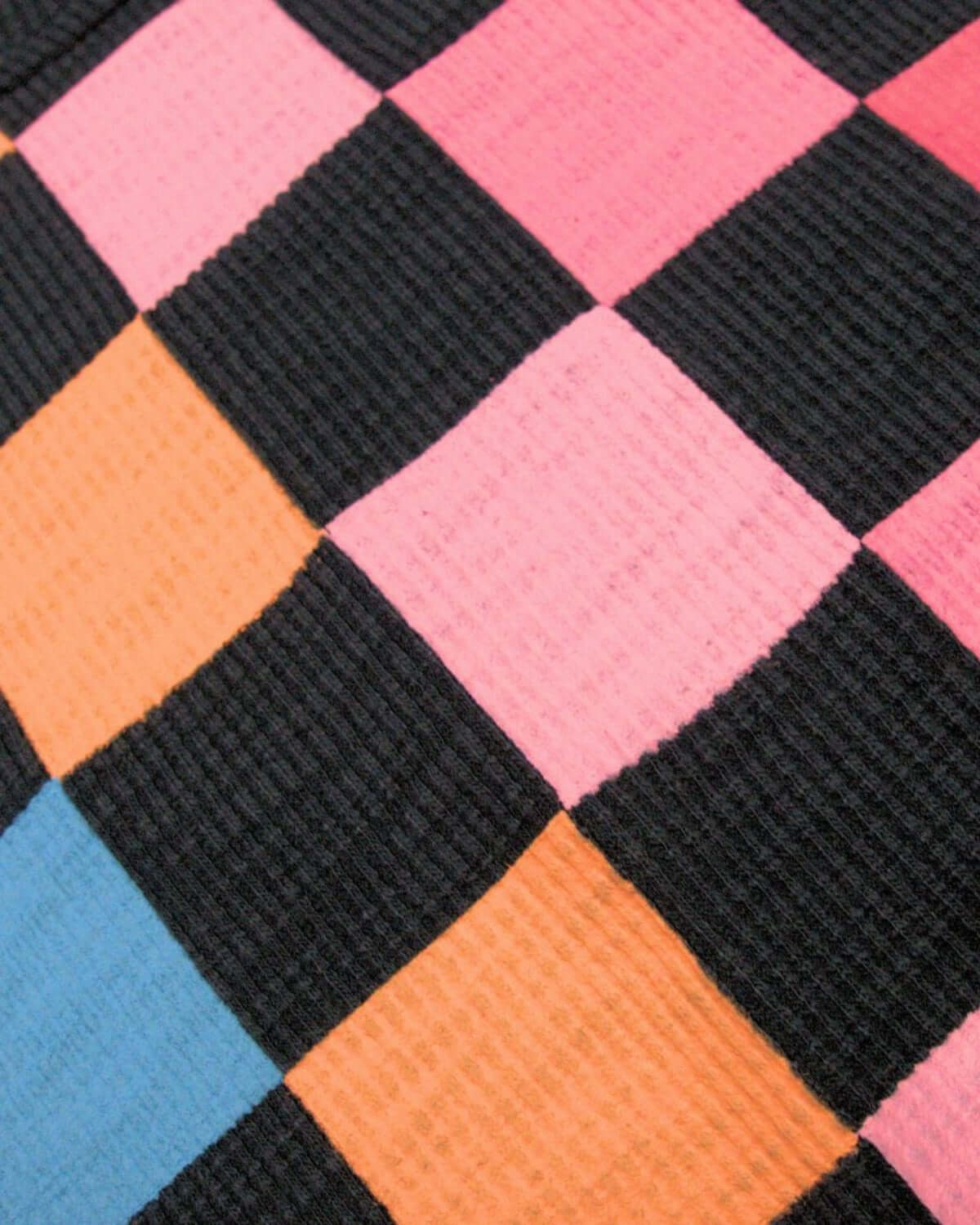 Close-up of vibrant navy and colorful checkerboard pattern on a chic Ruby Sweatshirt, perfect for stylish kids' outfits.