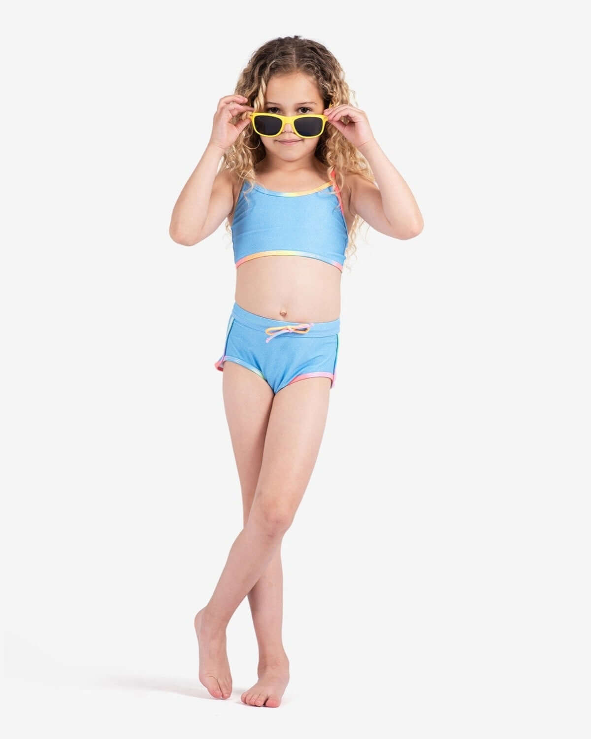 Stylish kid in a blue high waist bikini with sunglasses, ready for summer fun and sun protection!