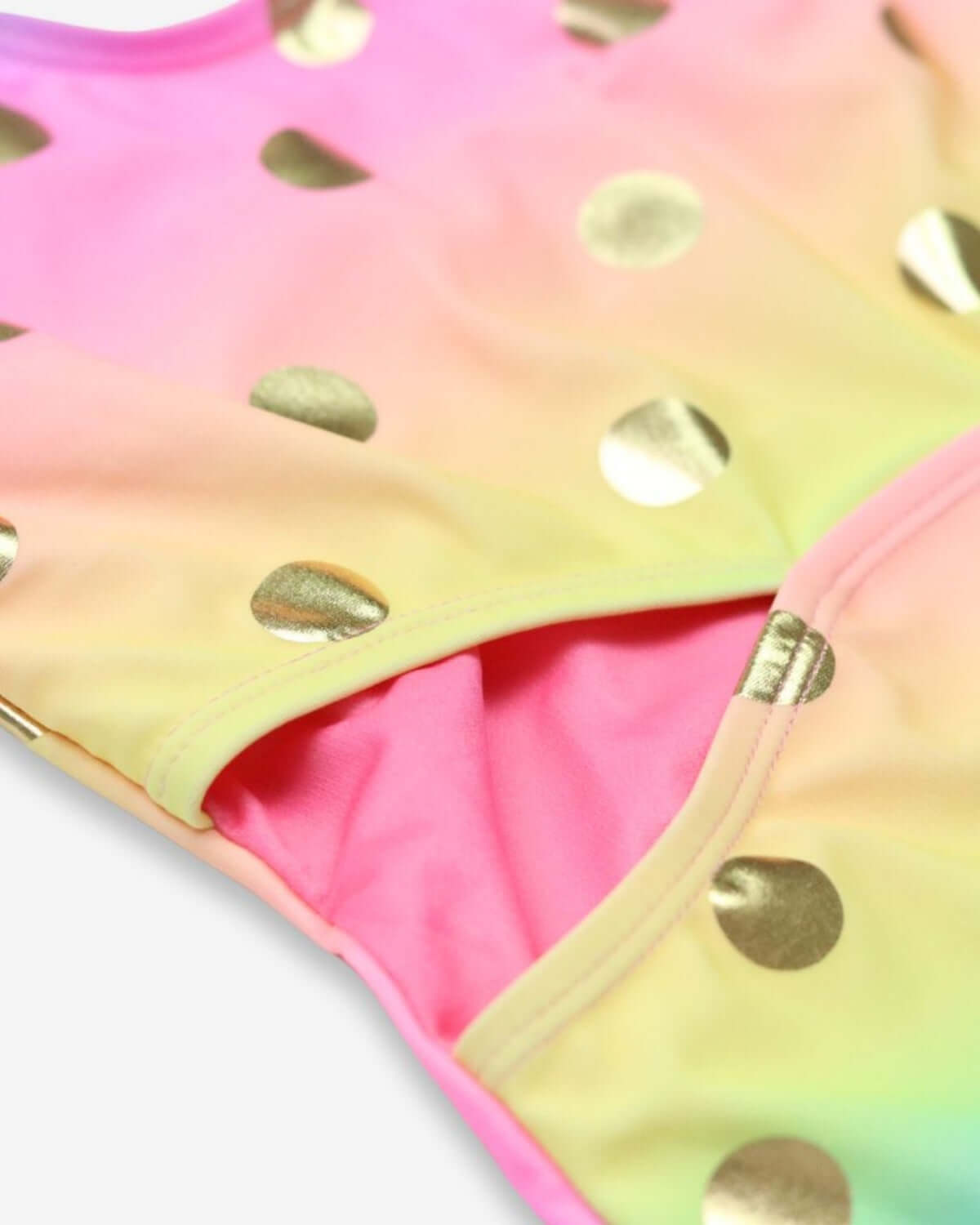 Close-up of vibrant Rainbow Dots Erika Swimsuit for kids, featuring shimmering gold polka dots and soft fabric.