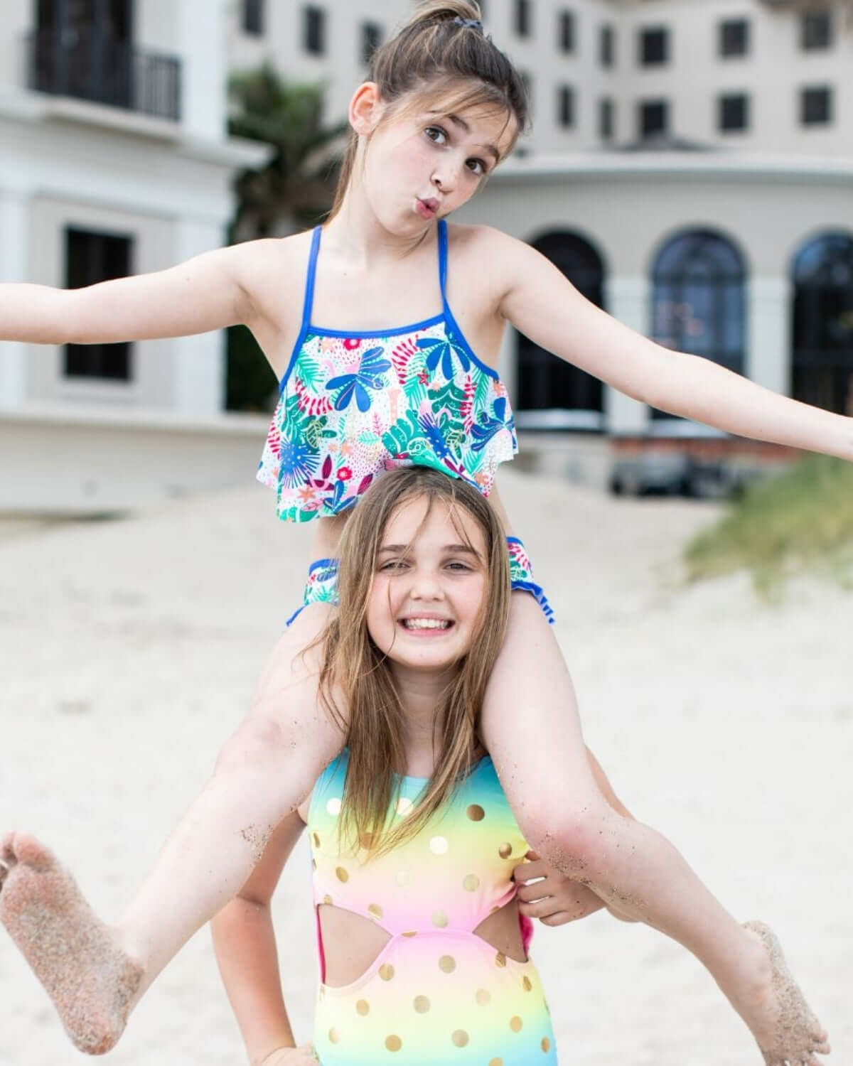 Two kids having a blast at the beach, rocking colorful swimsuits, ready for fun under the sun!
