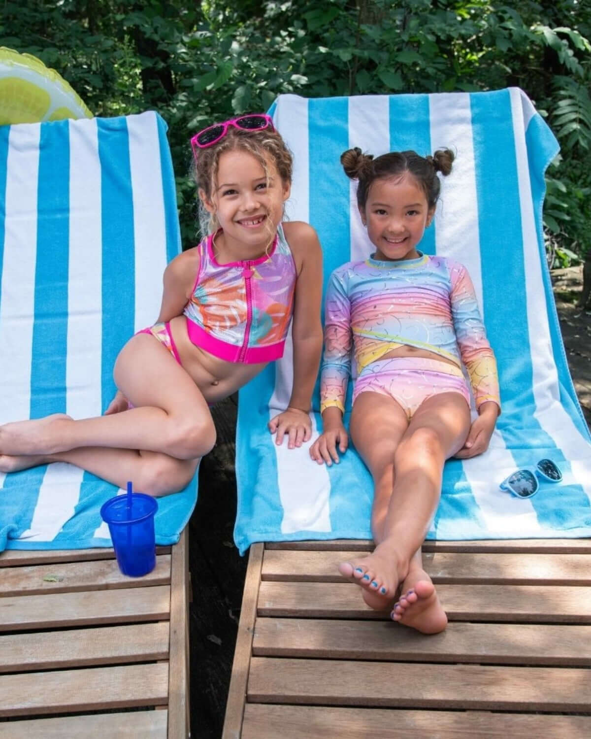 Summer Joy Oceana Bikini on two girls lounging by the pool, showcasing vibrant colors and summer fun.